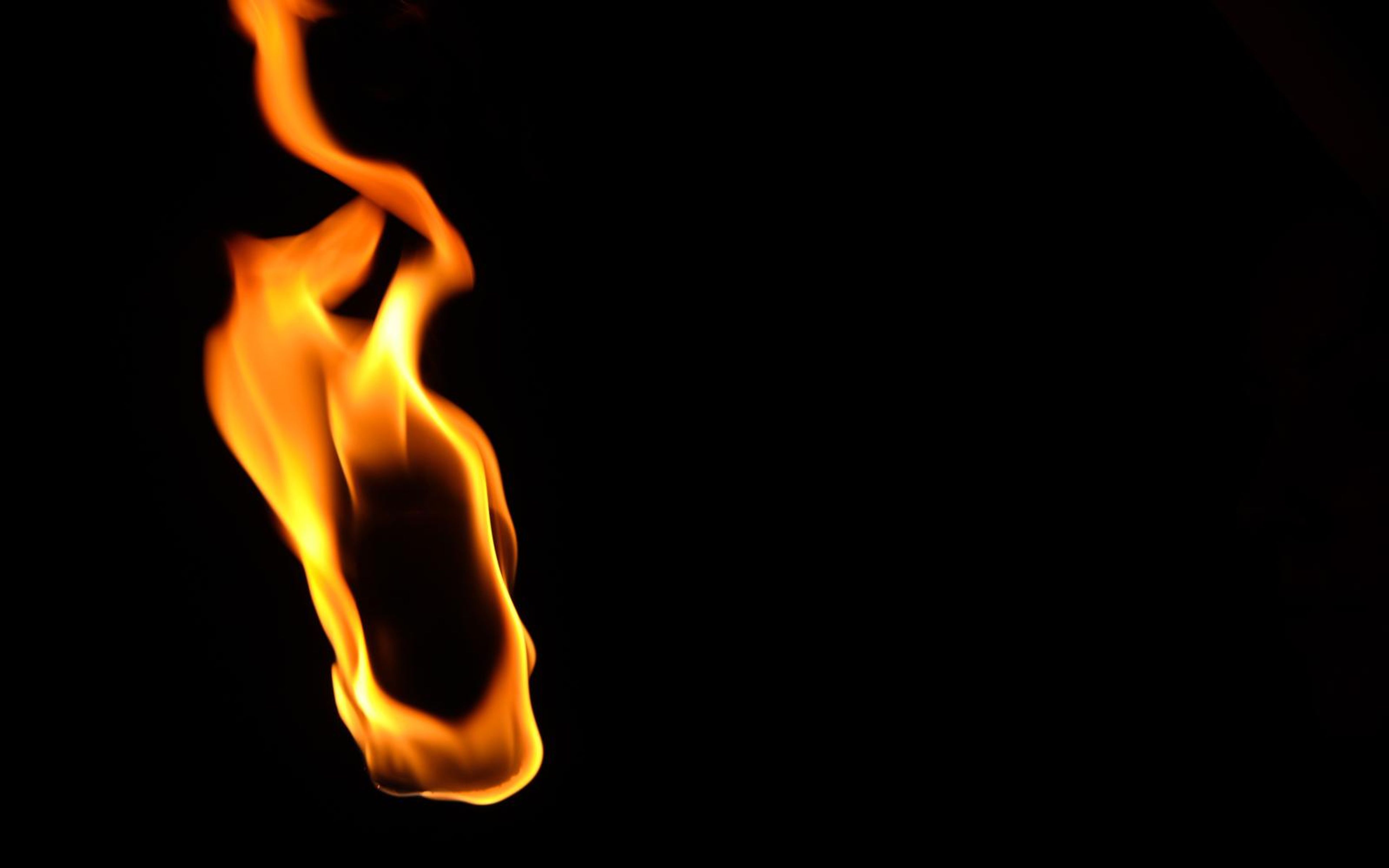 Flame bending to the left with a long tail rising at the top