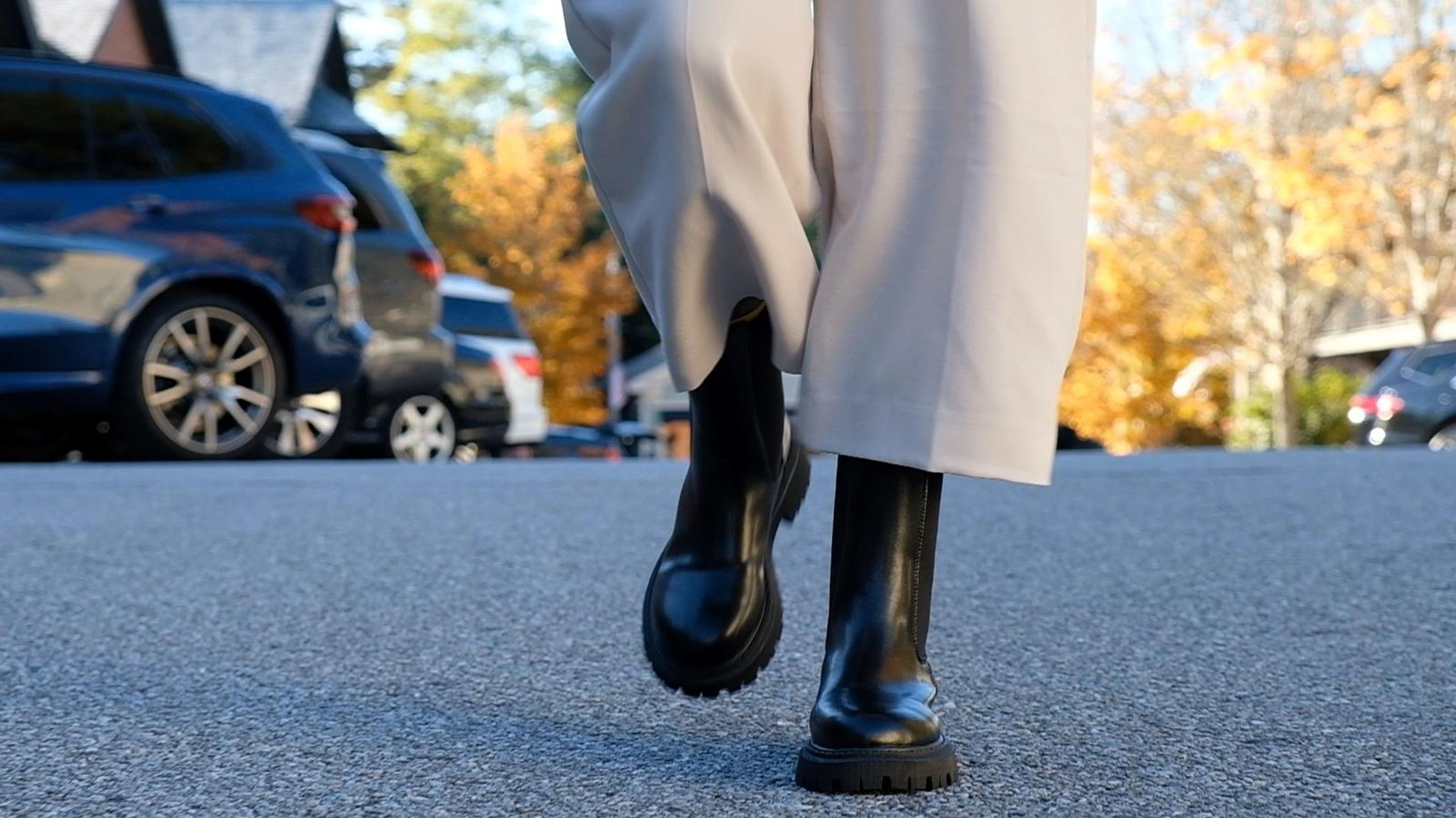 Frame of boots and cream trousers striding toward the camera