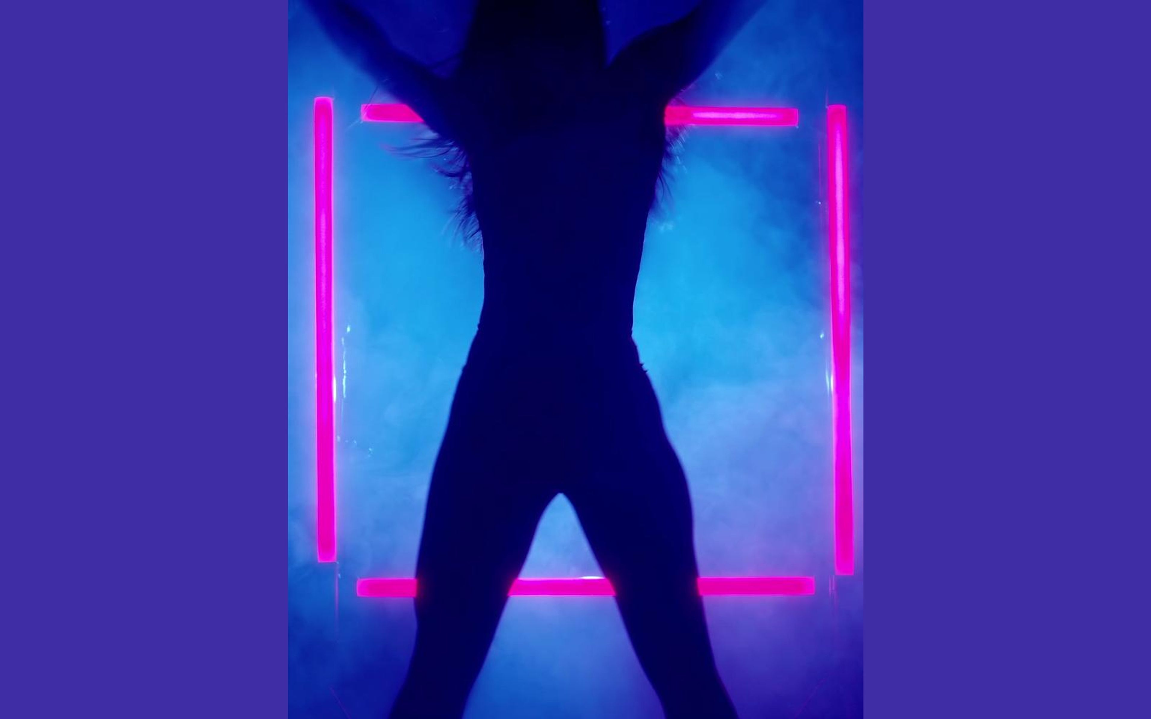 Dancer in silhouette inside a frame of pink neon tubes with blue smoke behind