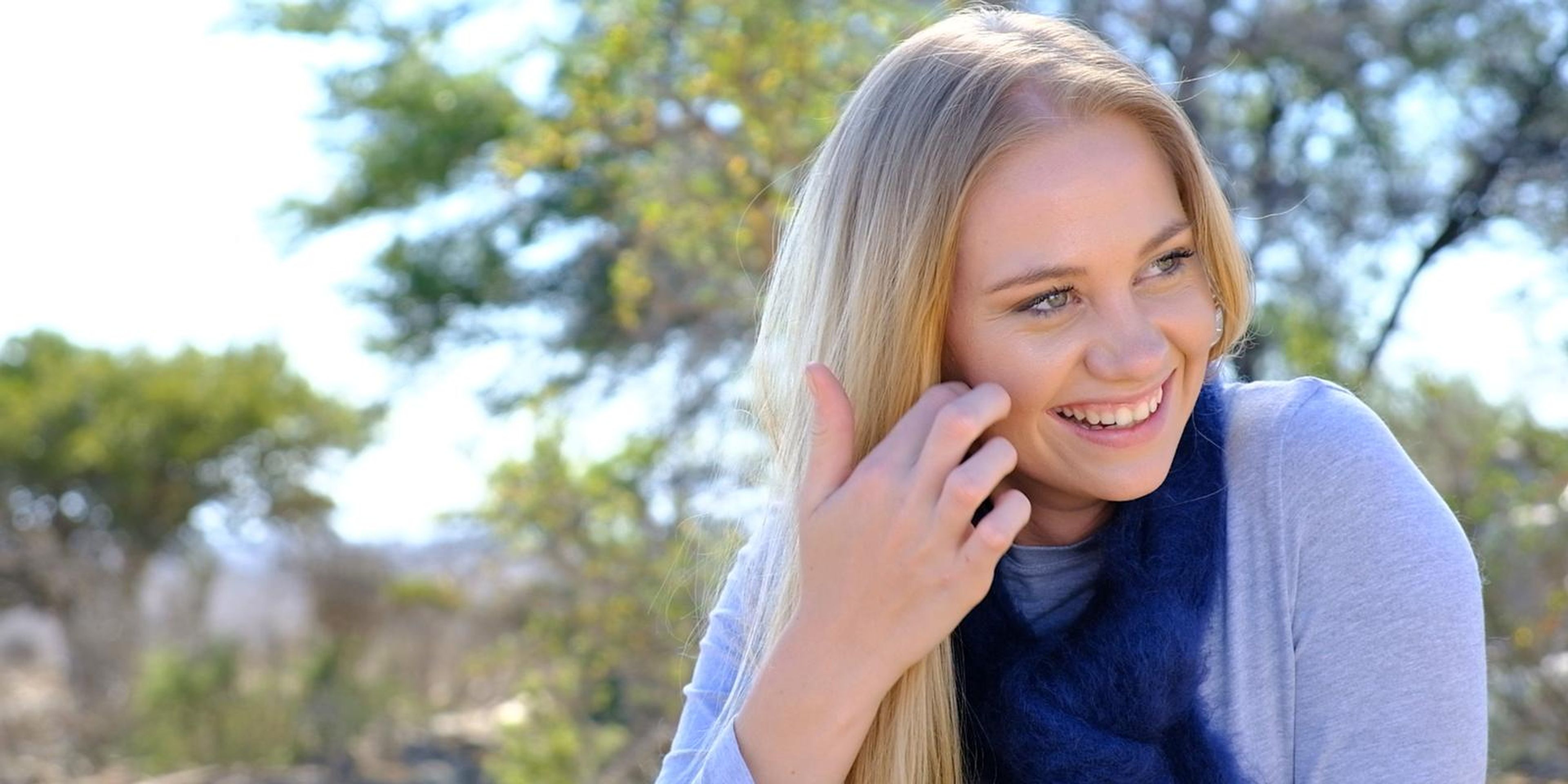 Model smiling in a blue mohair scarf and grey knit