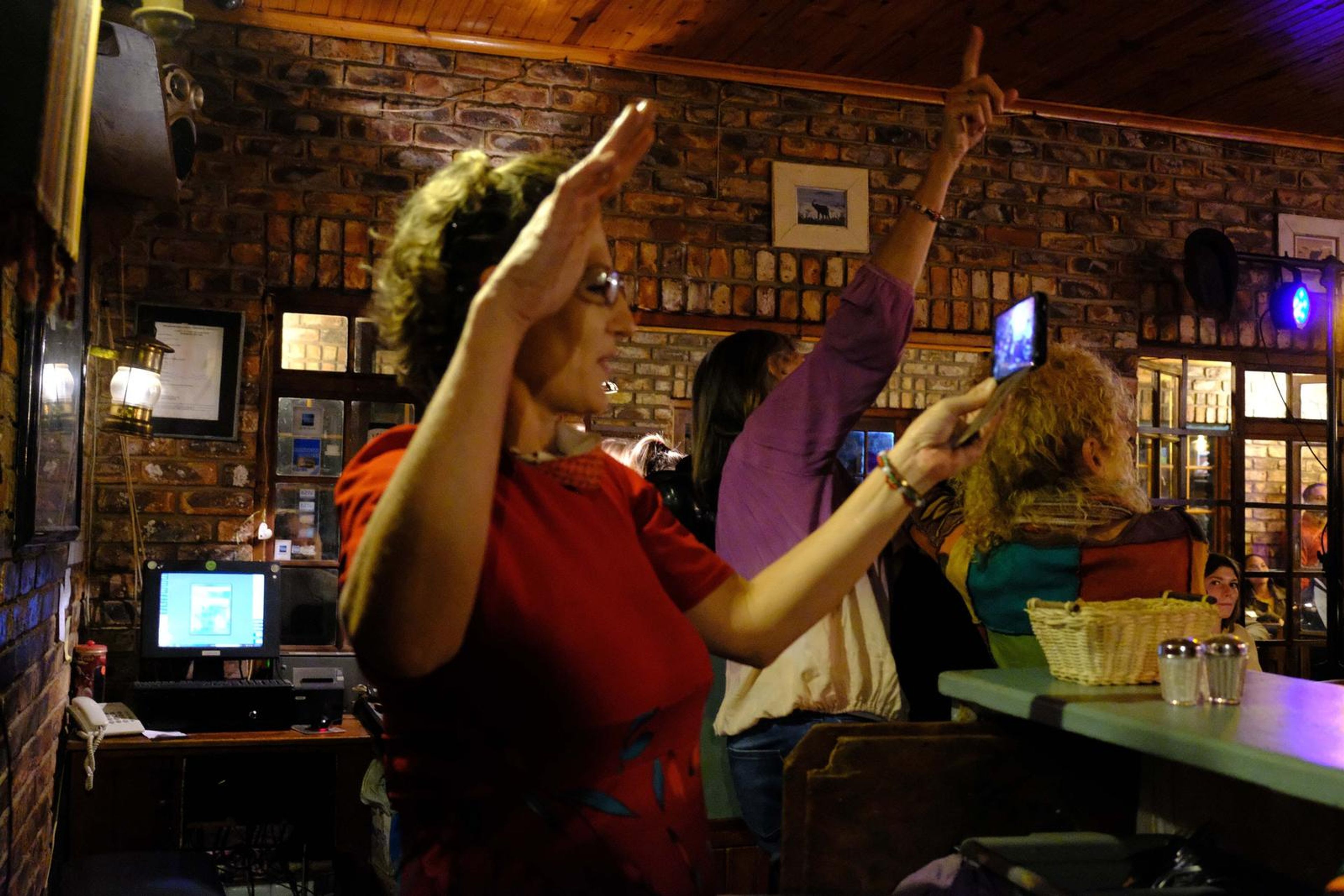 Guest raising her arm and pointing up while the band plays