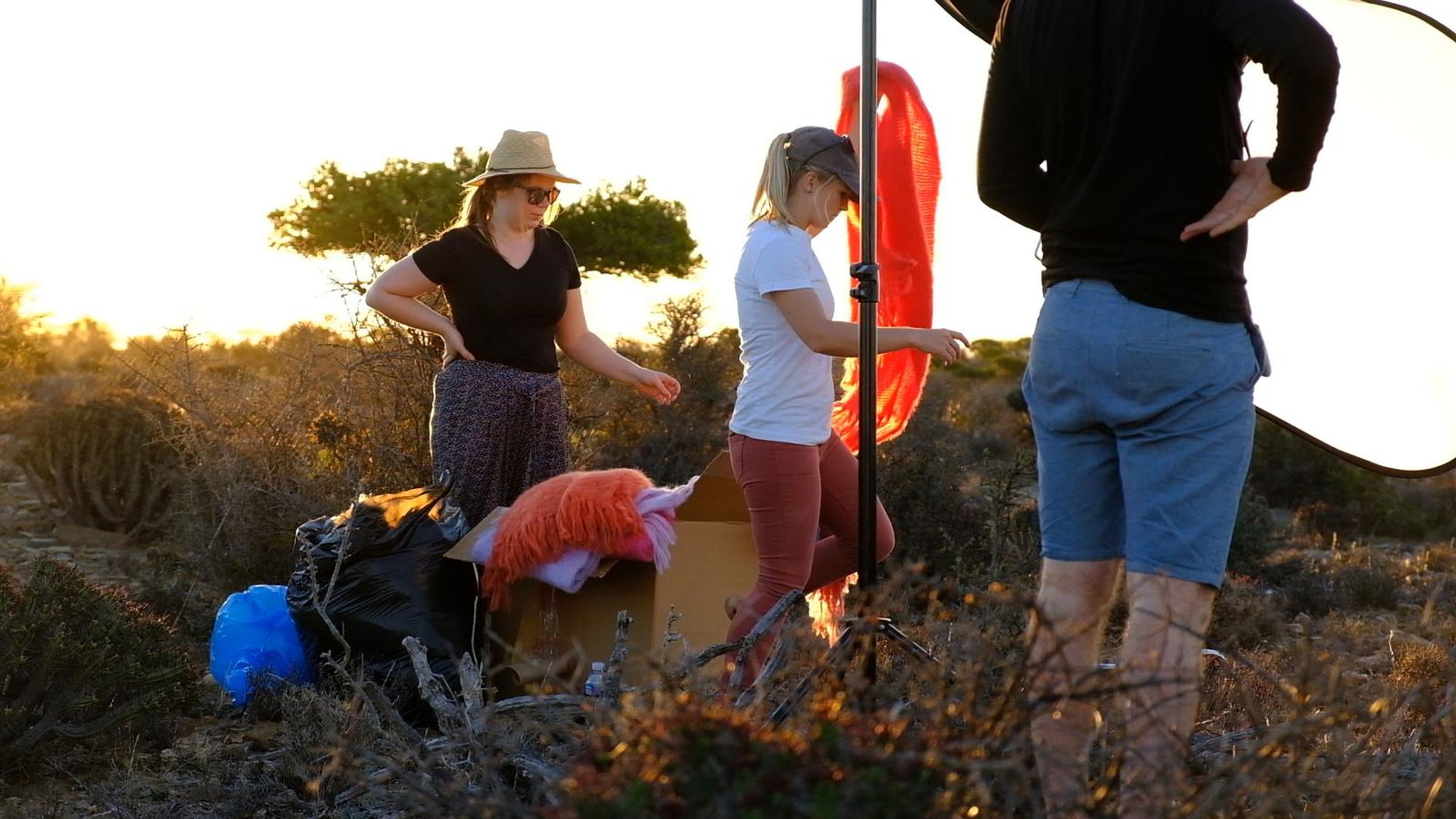 Stylists gathering wraps and scarves at the camp as the sun sets
