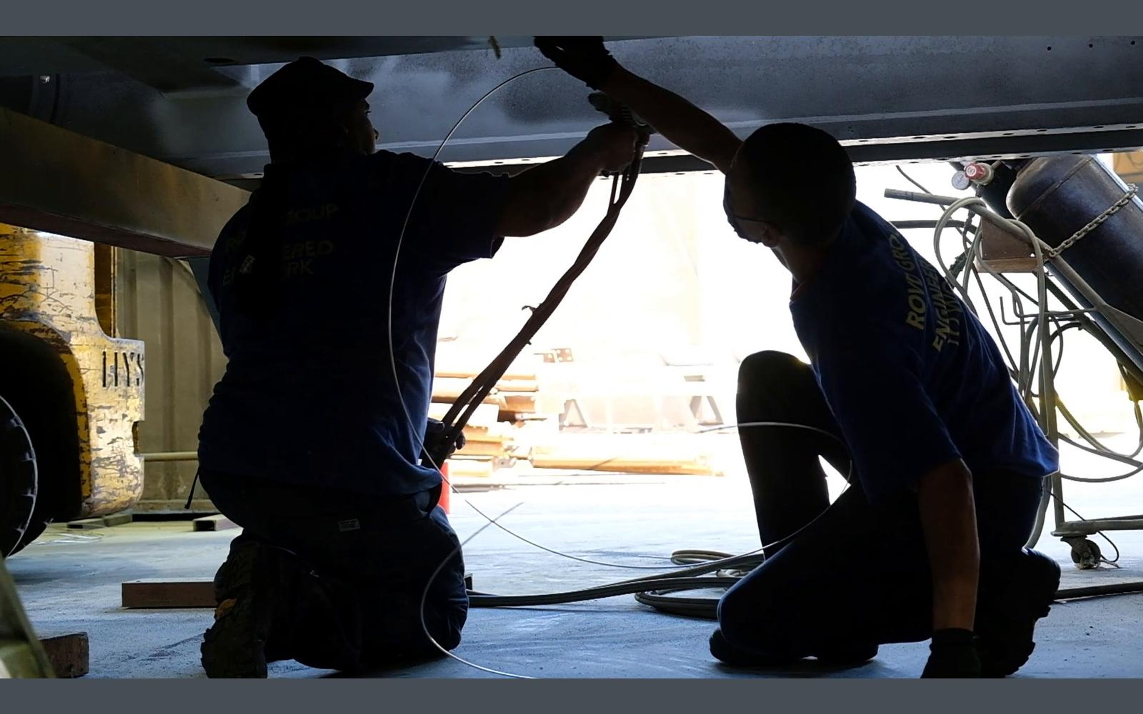 Painters working under a large steel component