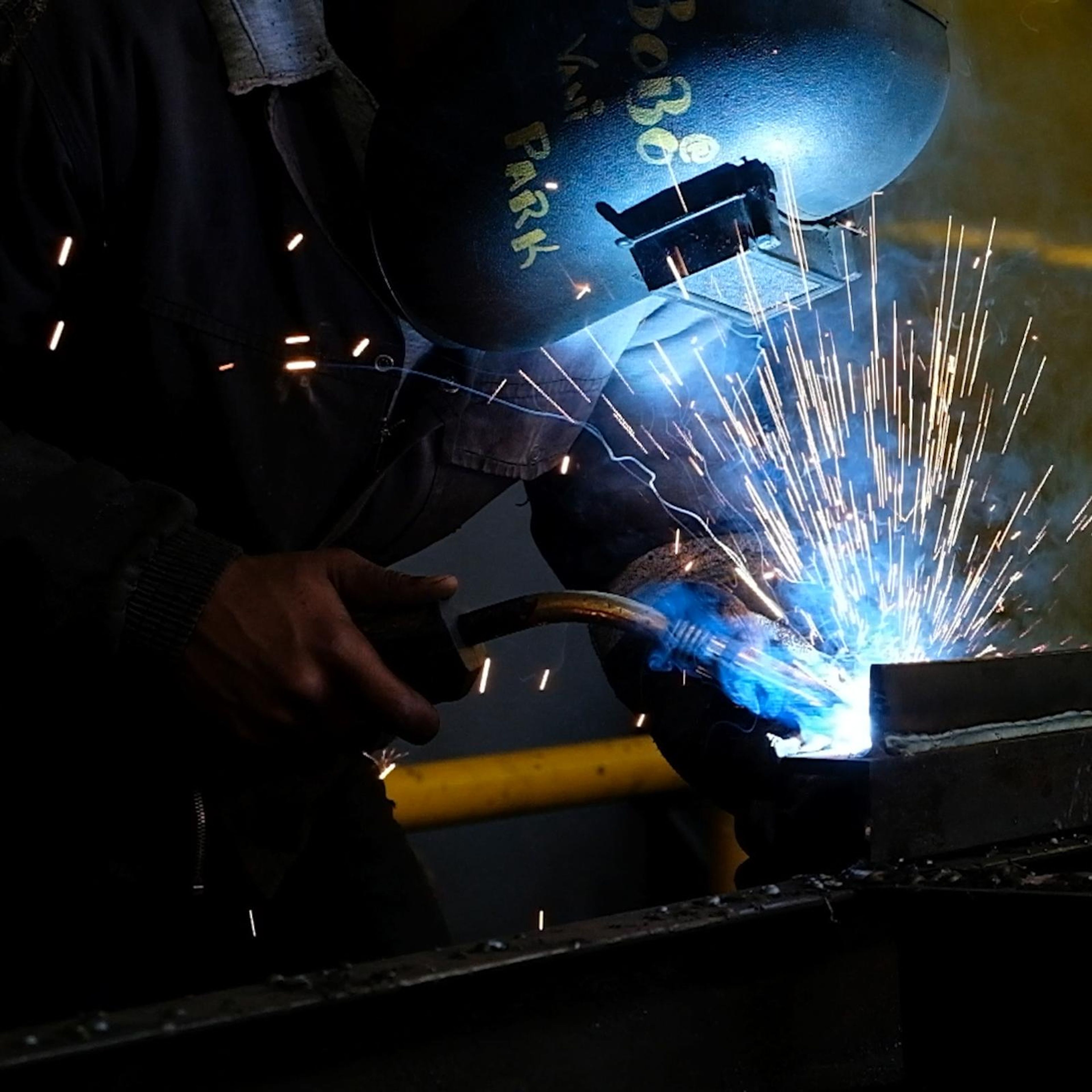 Square crop of a welder's torch striking a bright arc