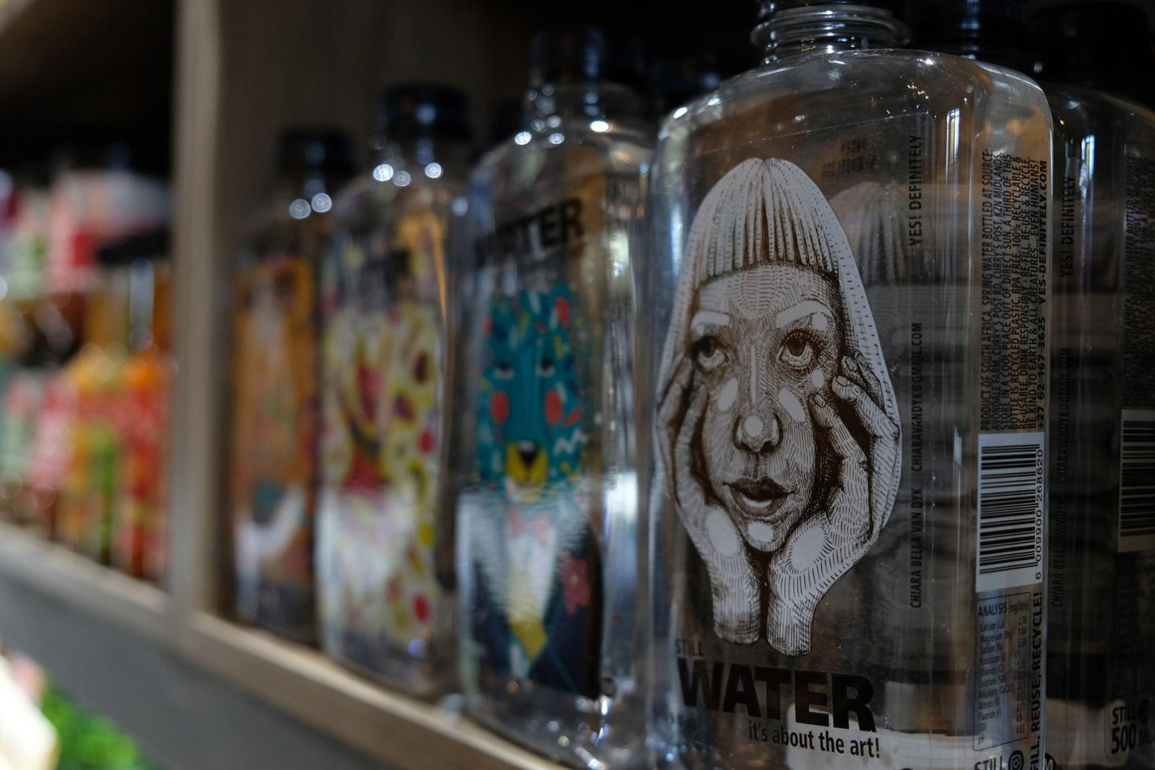 Shelf of illustrated Water bottles with hand-drawn labels