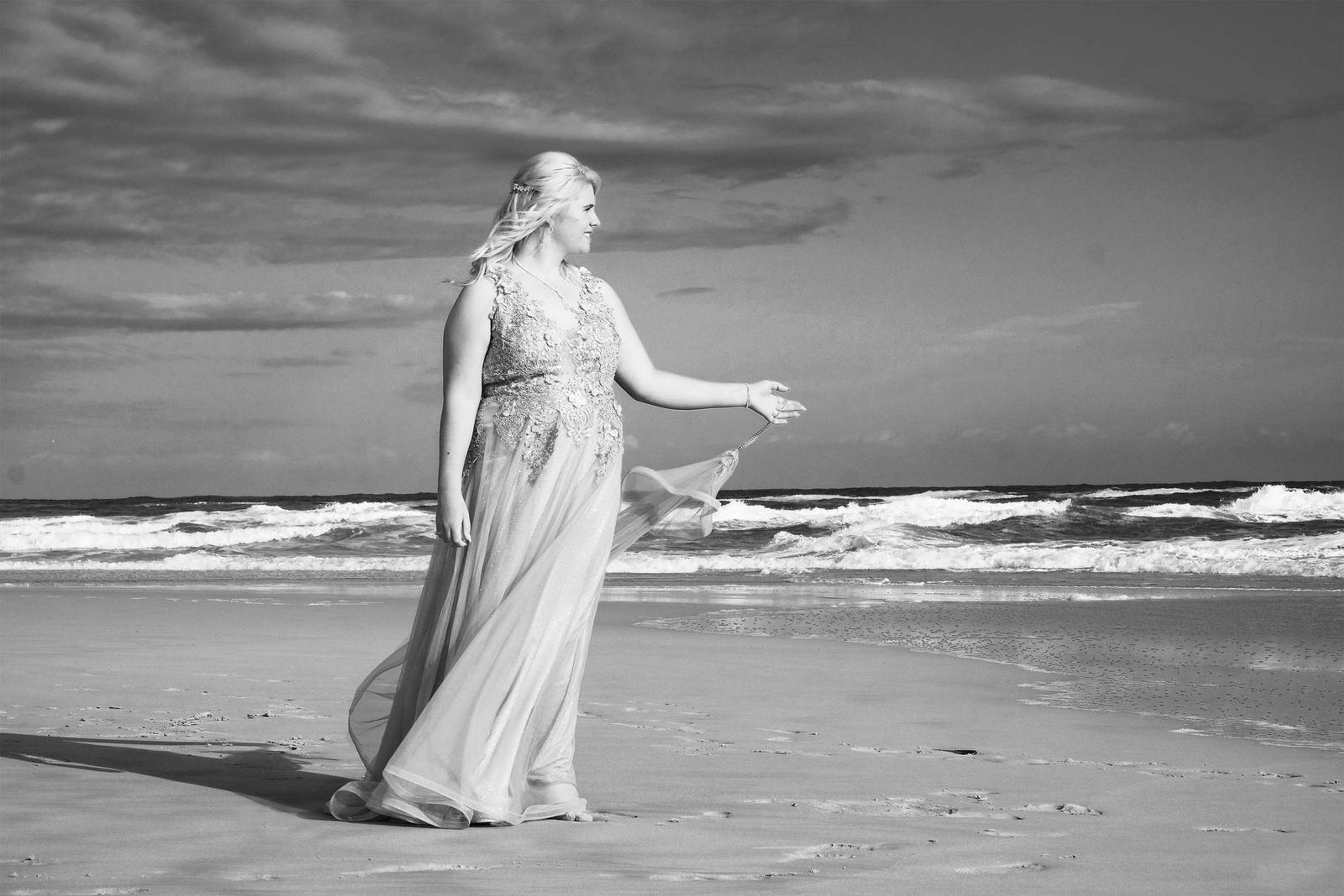 Black and white portrait gesturing towards the waves