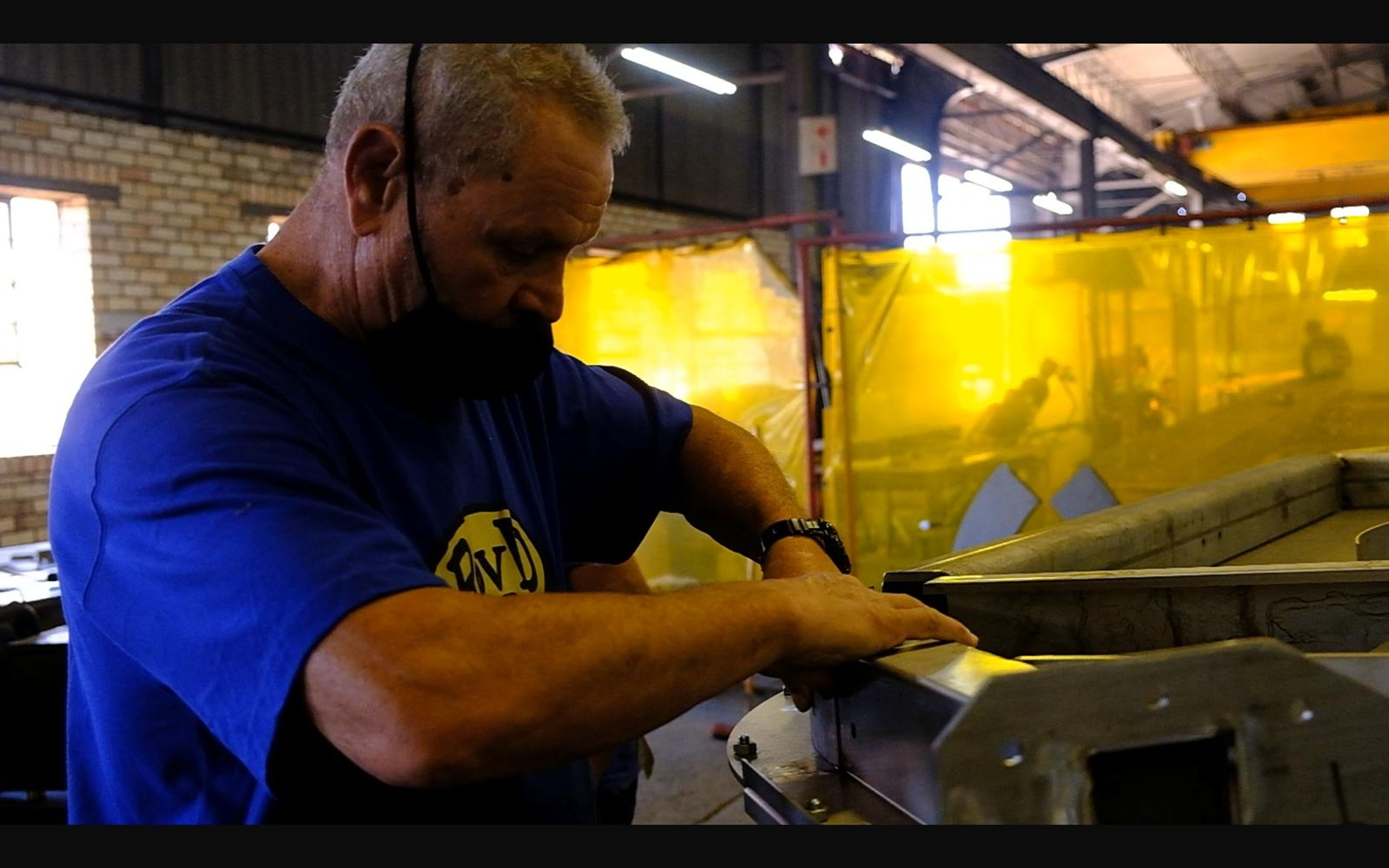 Two fabricators checking a steel assembly