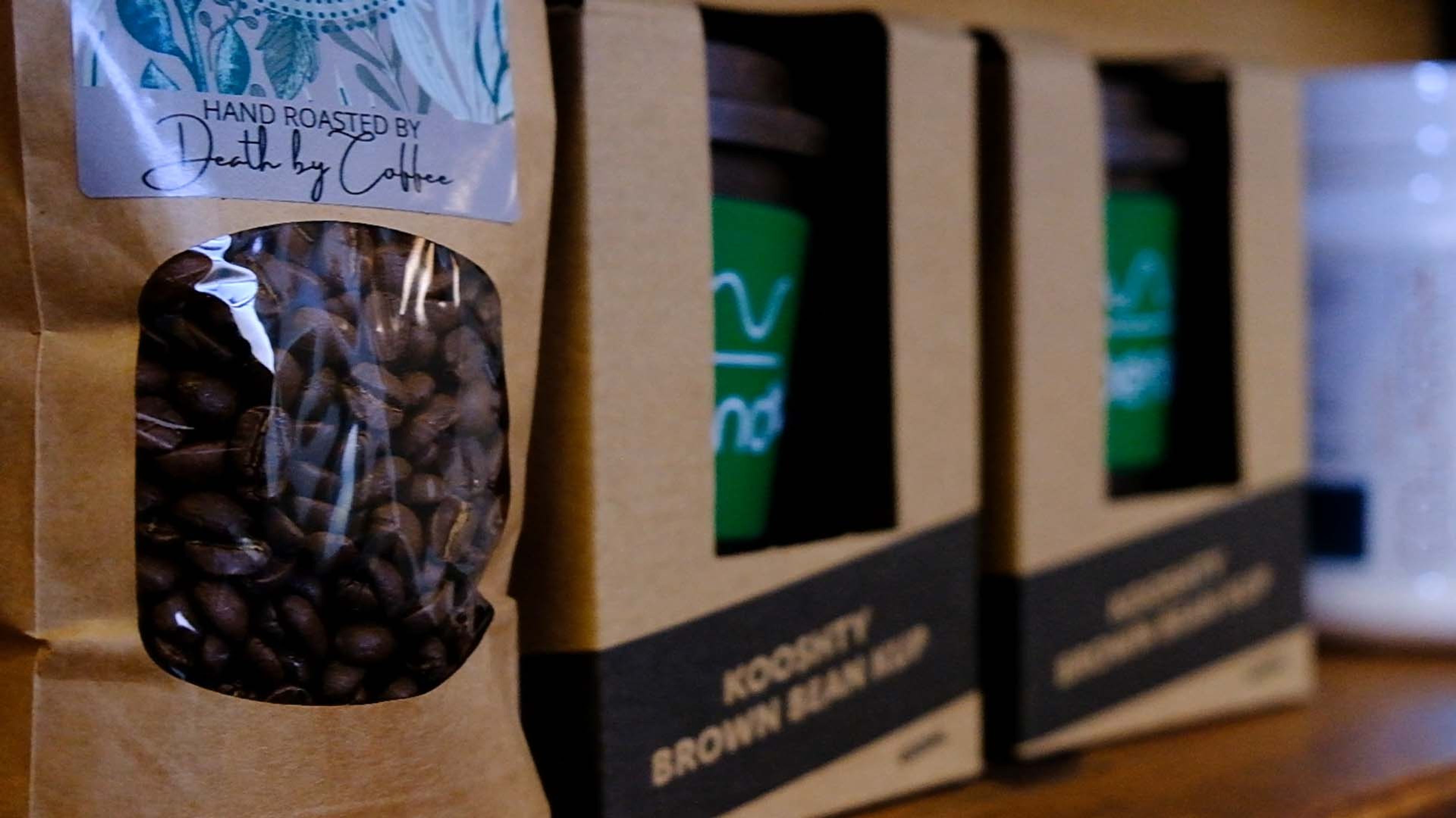 Bags of coffee beans and packaged snacks on a shop shelf