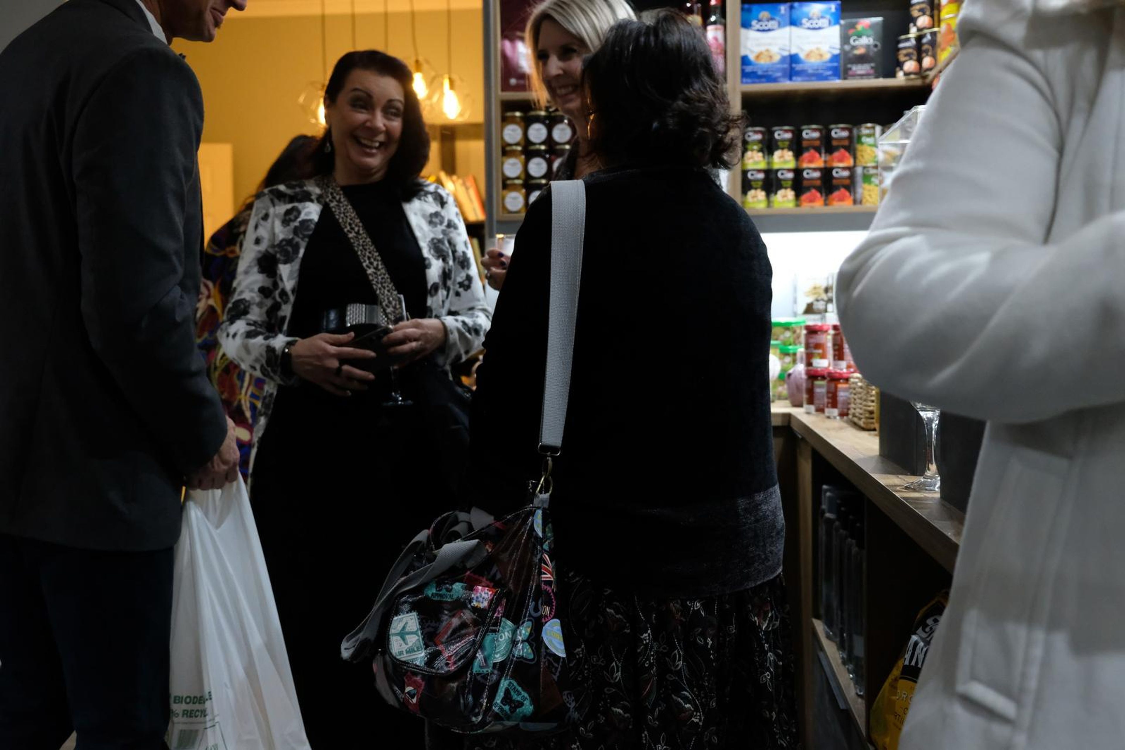 Guests laughing together beside the counter with the pantry shelves behind