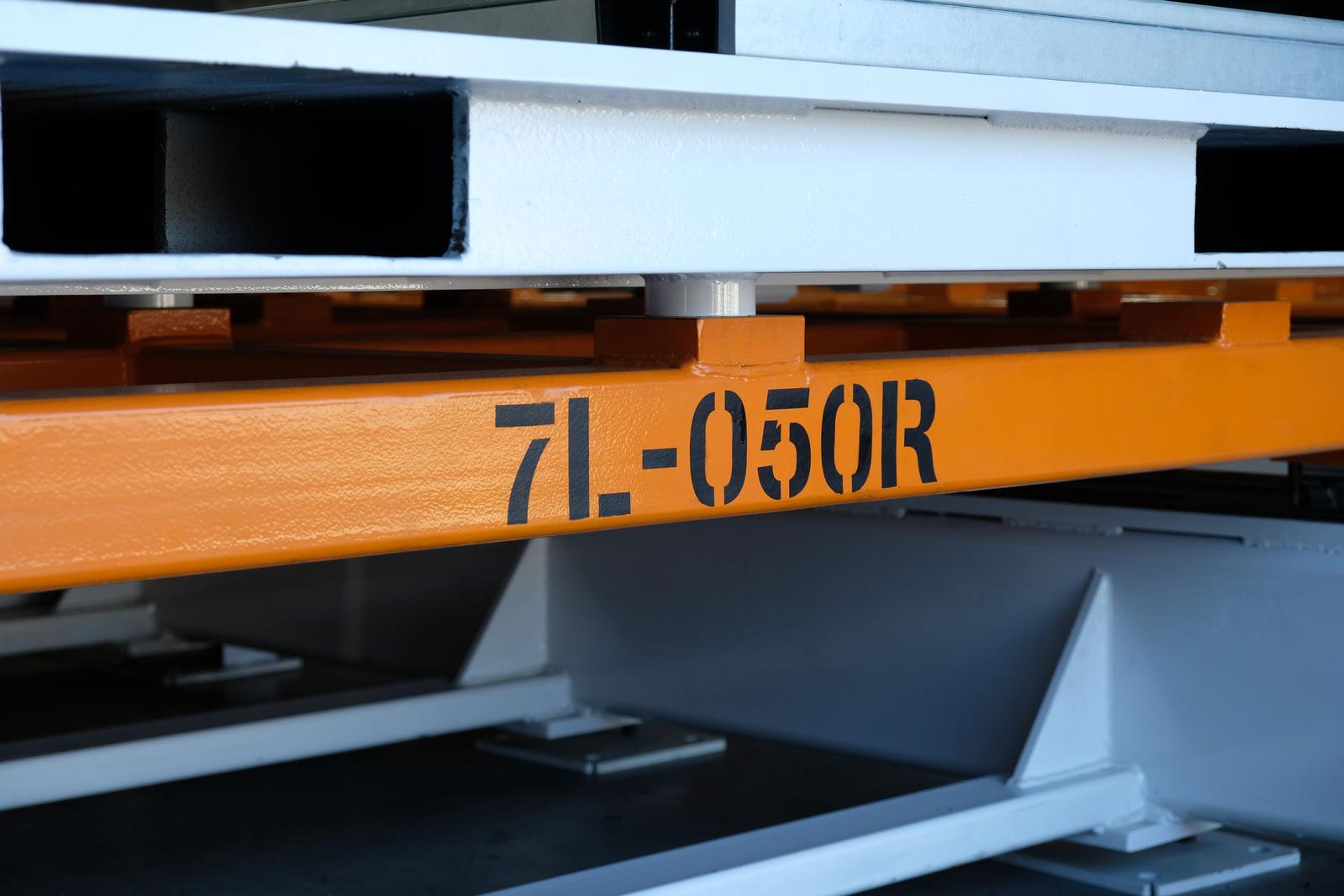 Orange beam stencilled 7L-050R above a white steel girder
