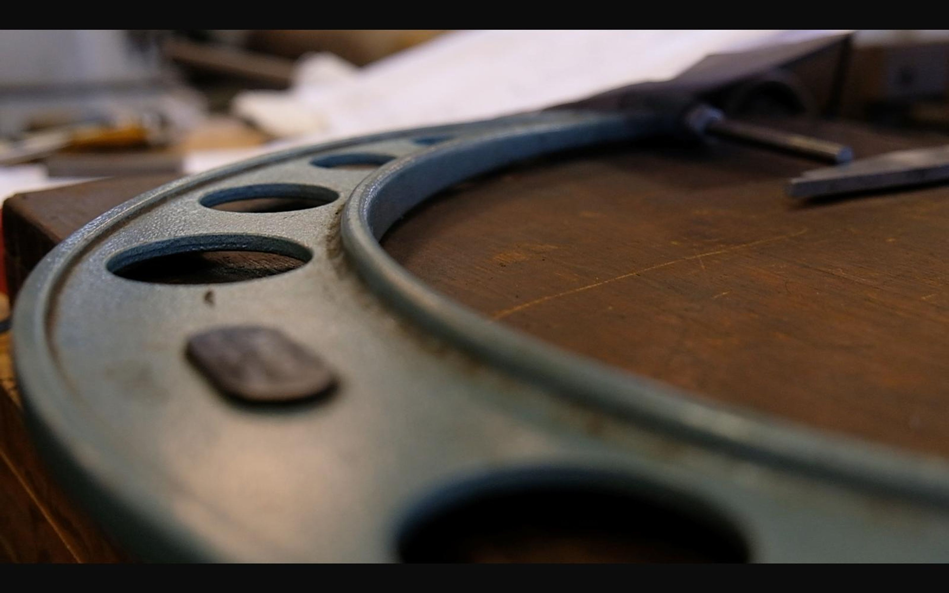 Large machined ring with bolt holes on a bench