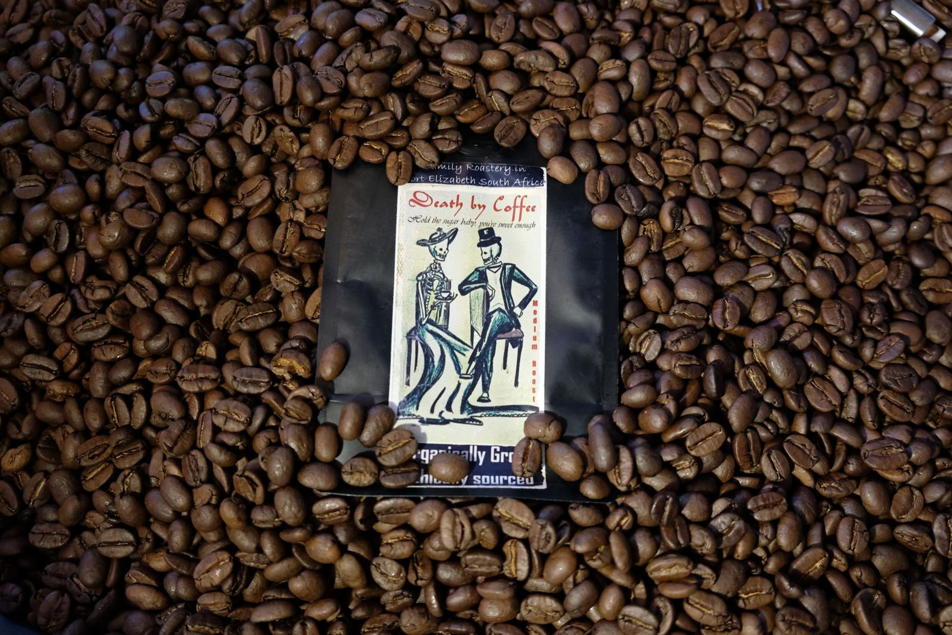Death By Coffee creative product photography of coffee, beans and branded bags