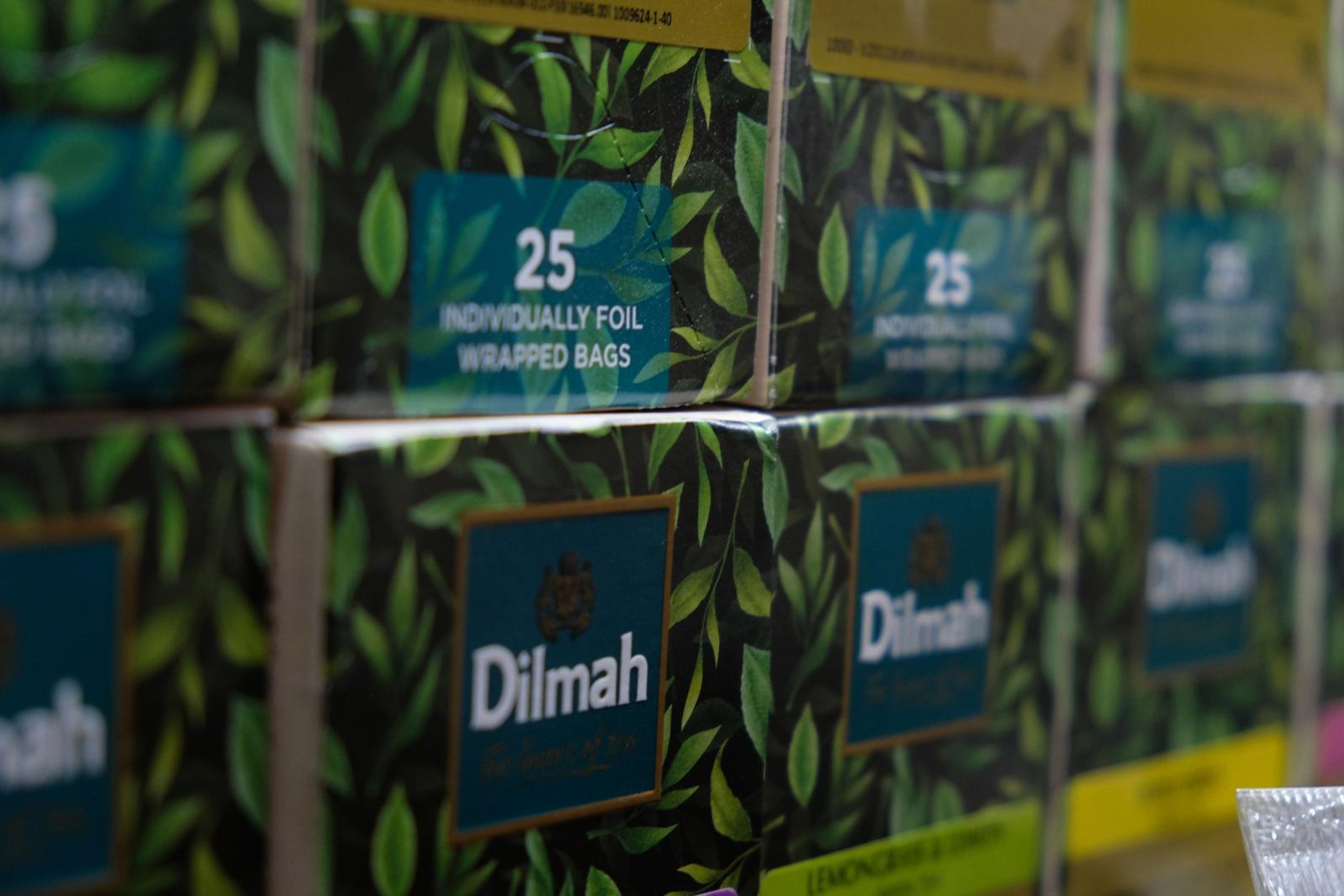 Stacked boxes of Dilmah tea on a shelf