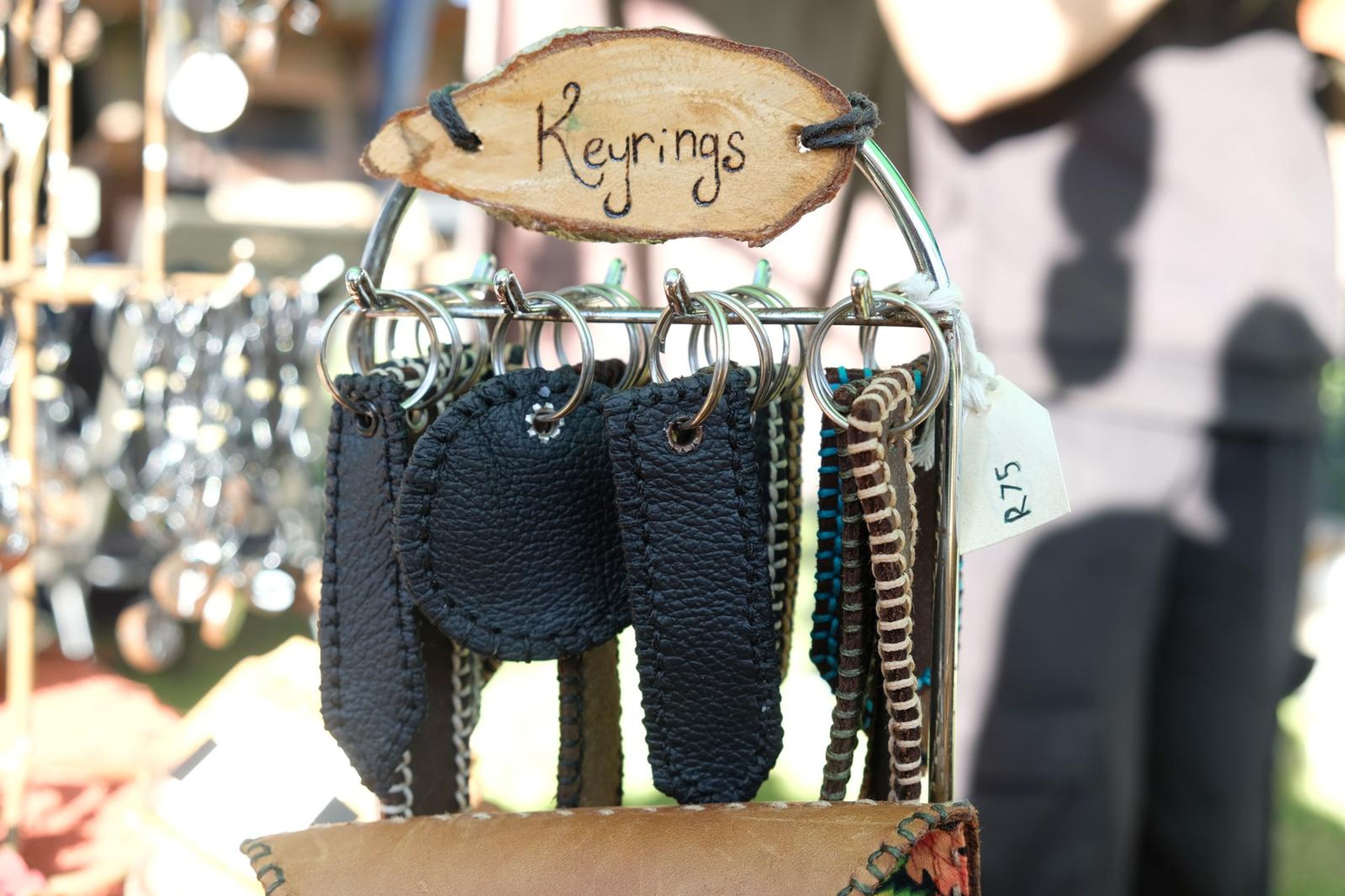 Hand-cut leather keyrings hanging from a Keyrings sign