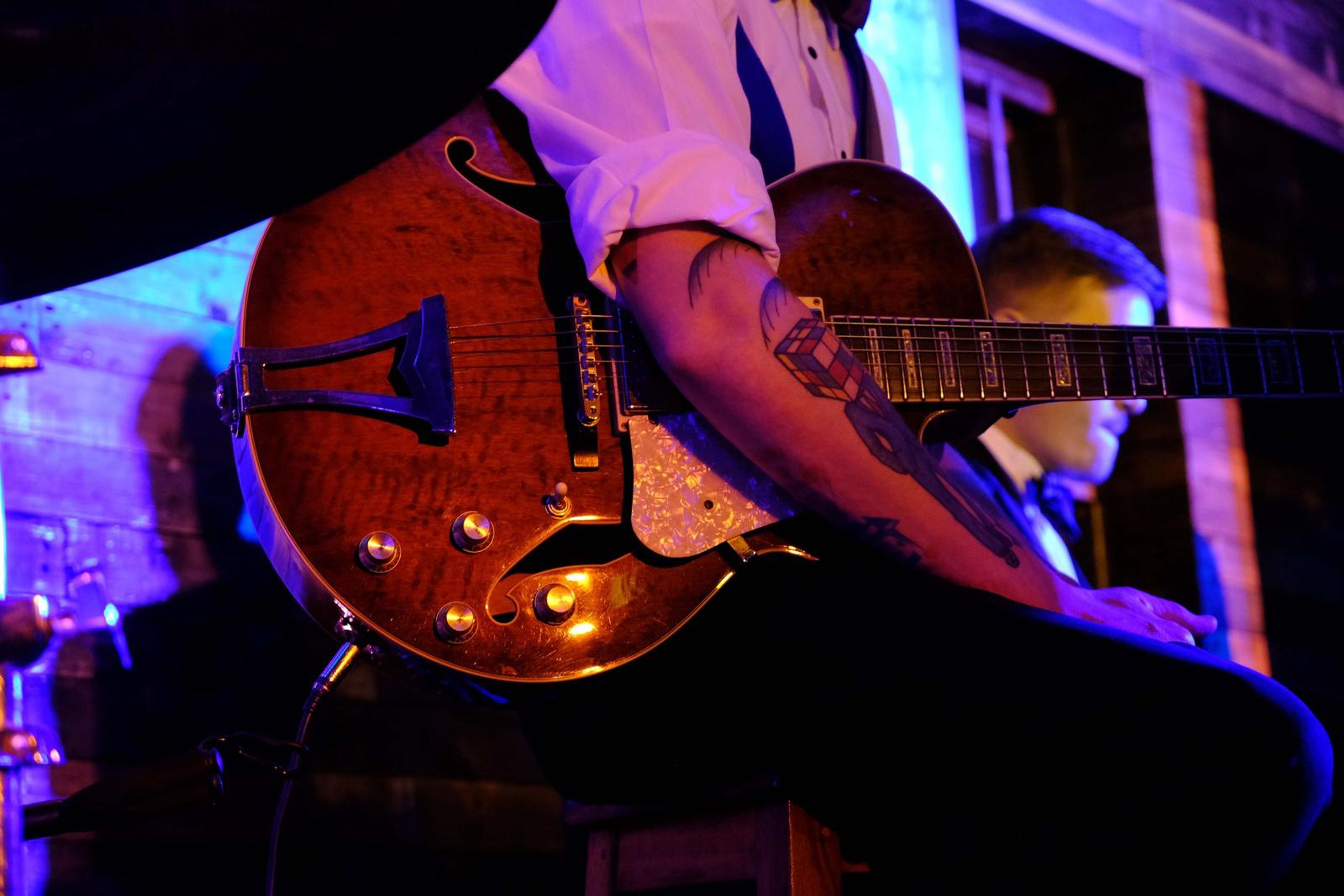 Close-up of an archtop guitar in blue light