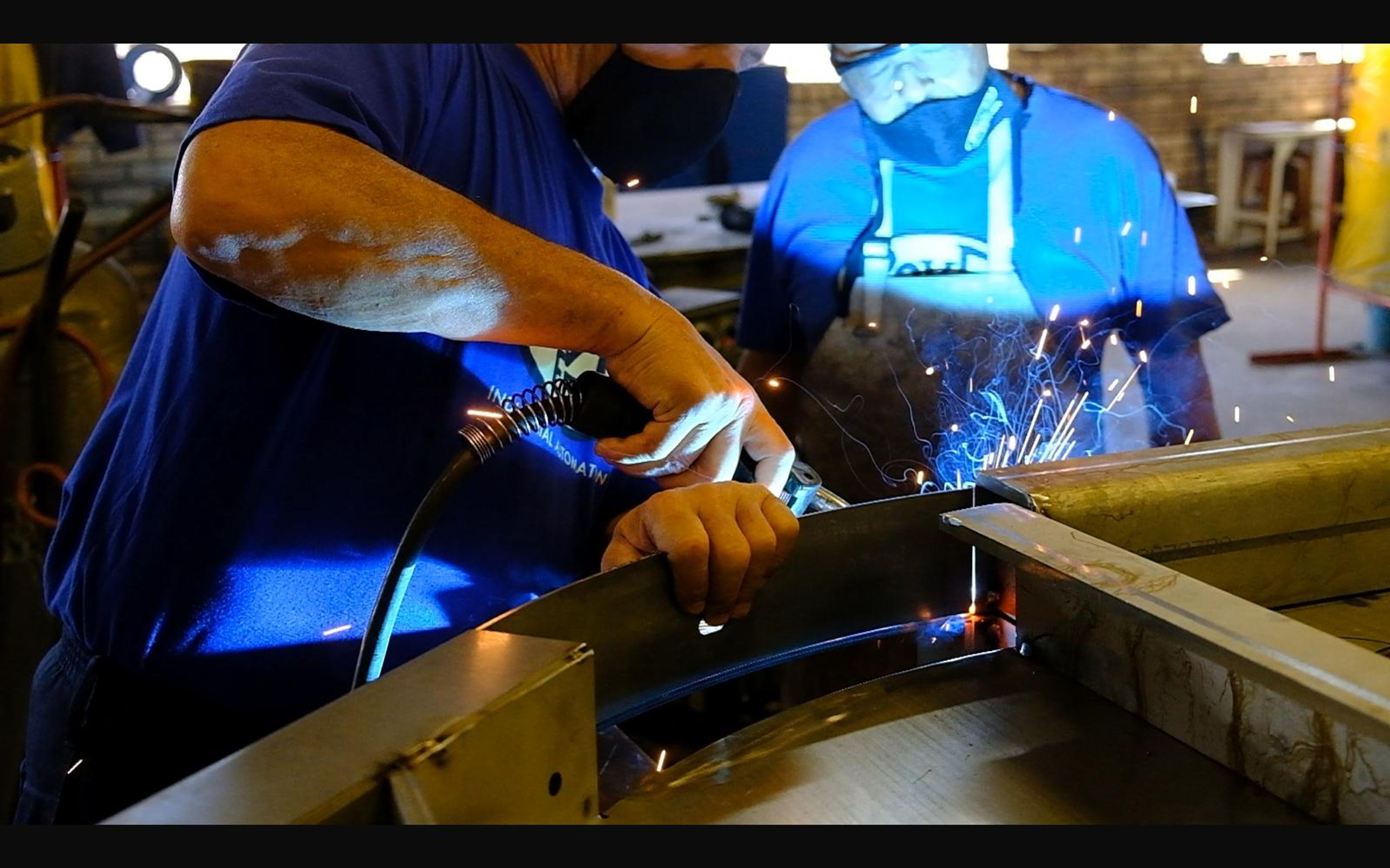 Welder joining plates on a workbench