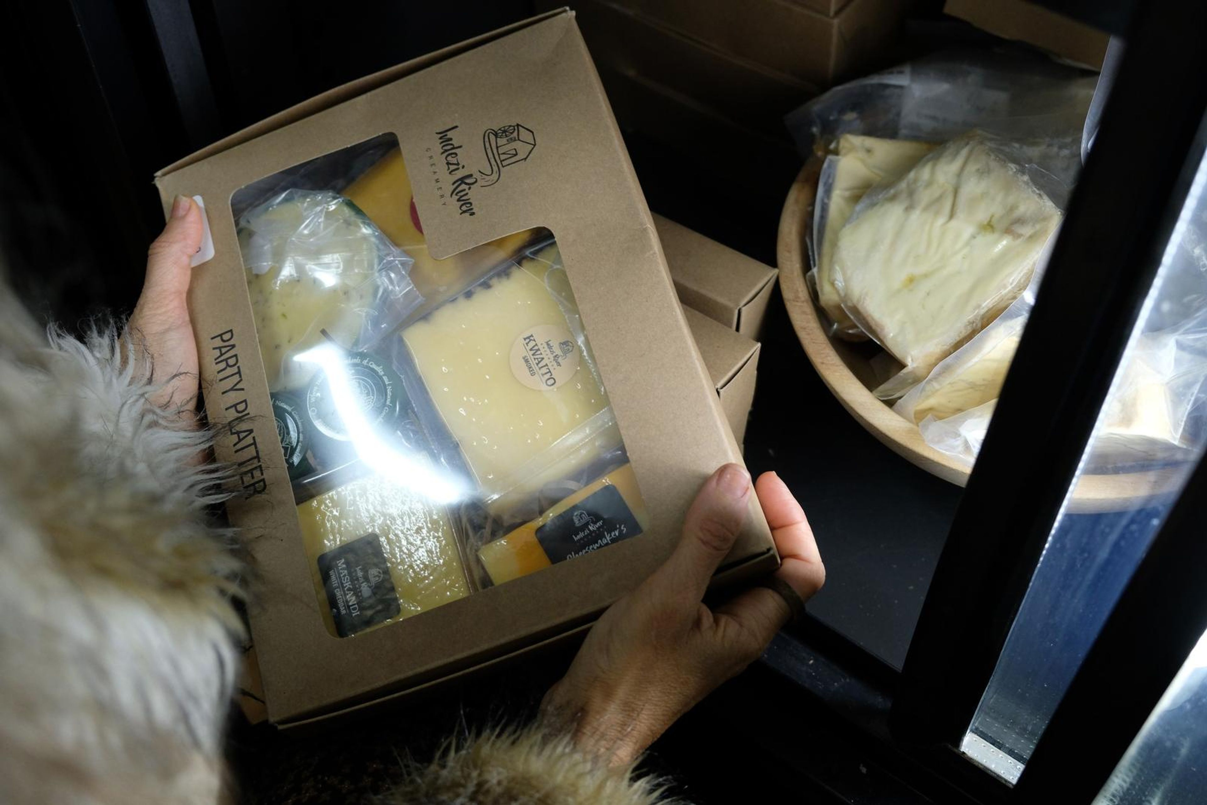 Hands holding a Party Platter box of local cheeses