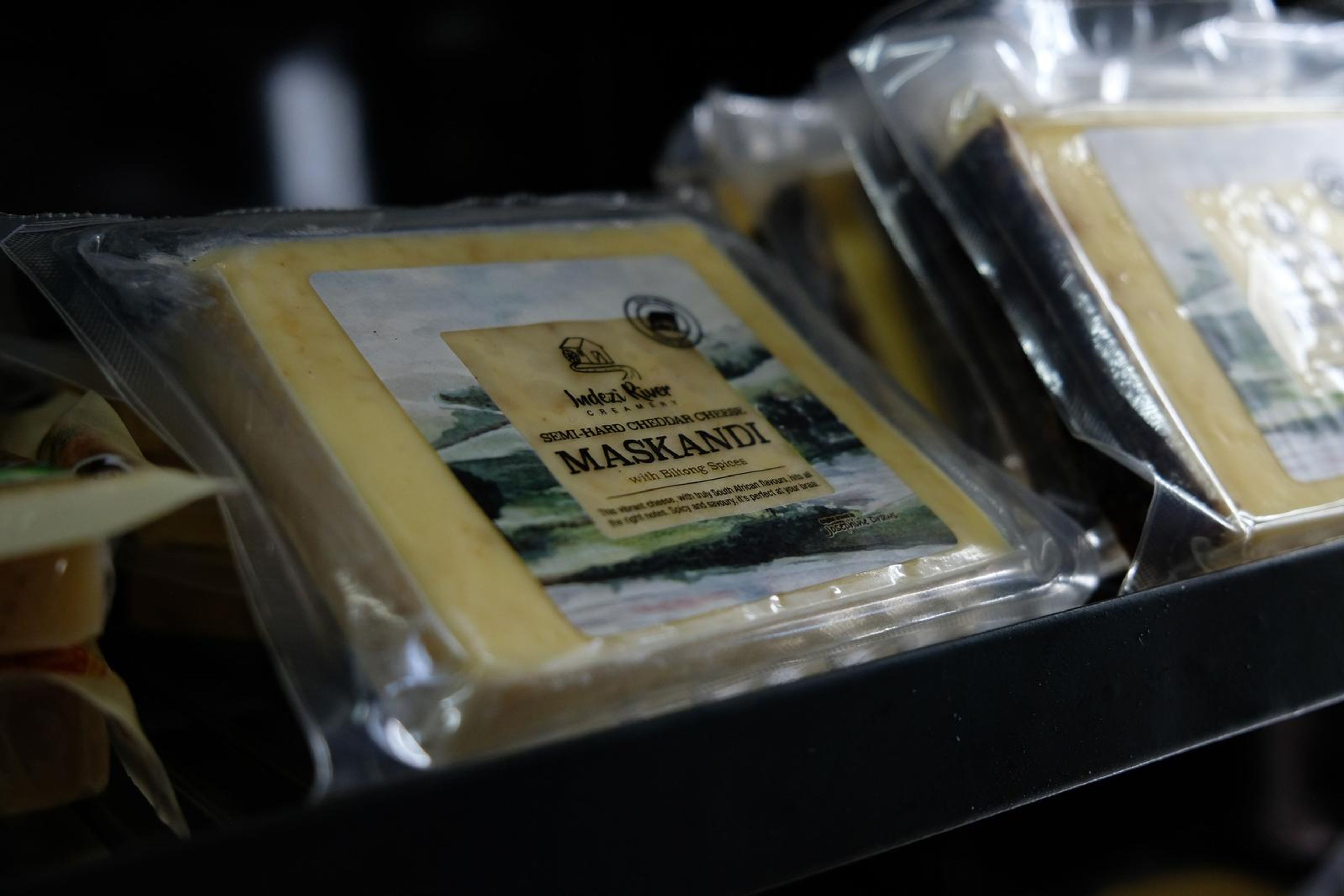 Wedge of Maskandi cheese in clear packaging on a fridge shelf
