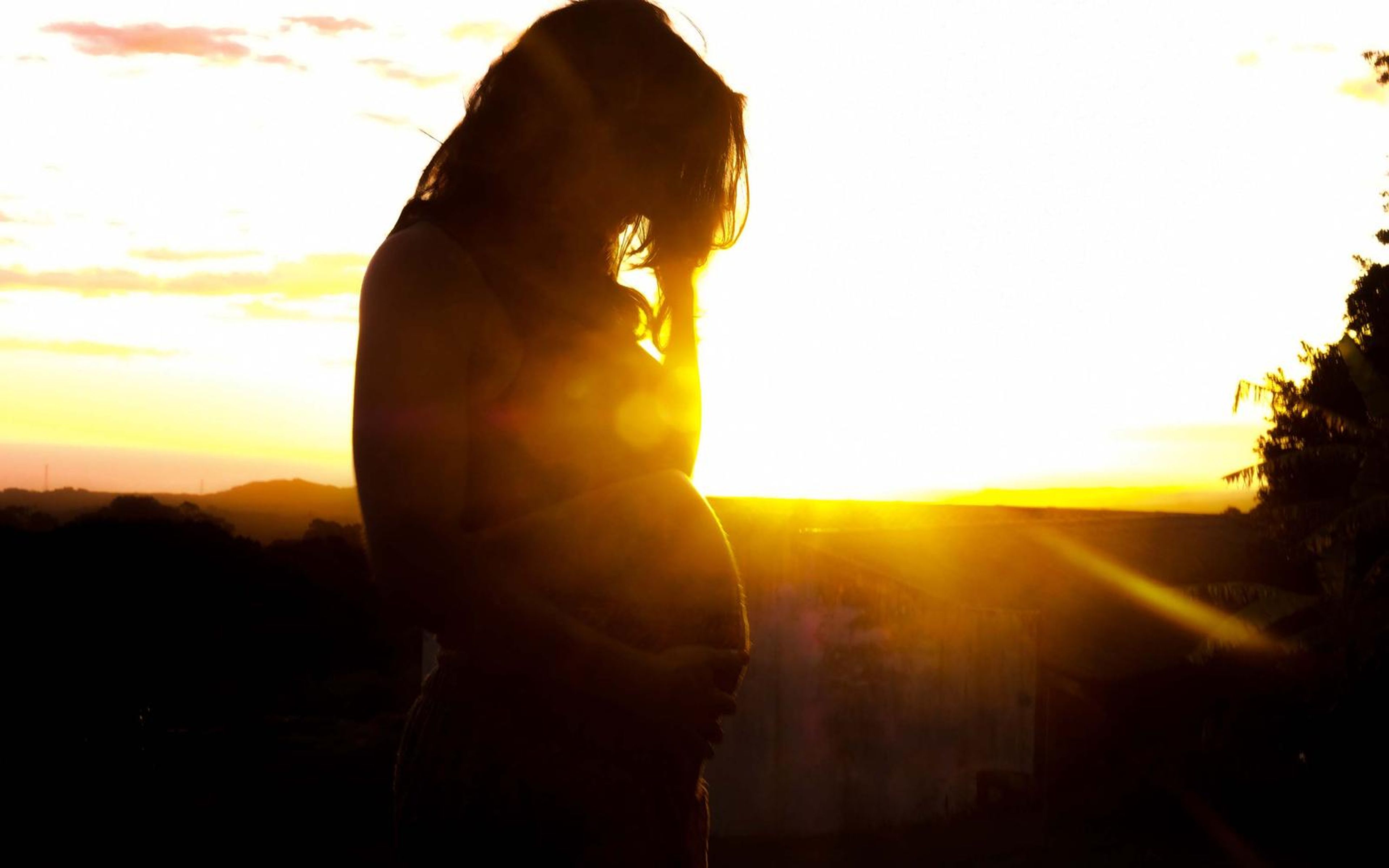 Low-key version of the backlit pose, sun flare and hair outlined in gold