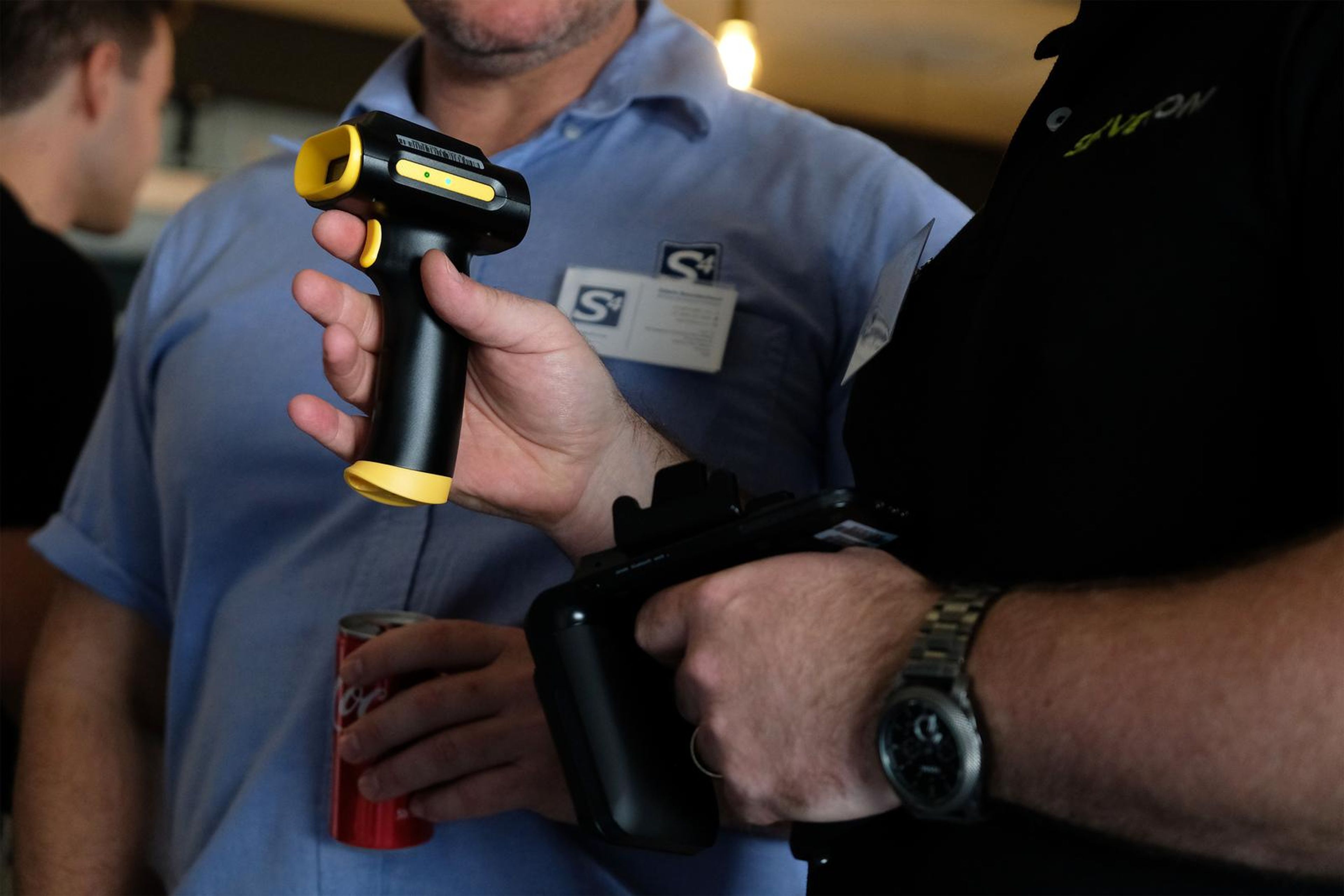 Servecom team member showing a handheld tool to a visitor