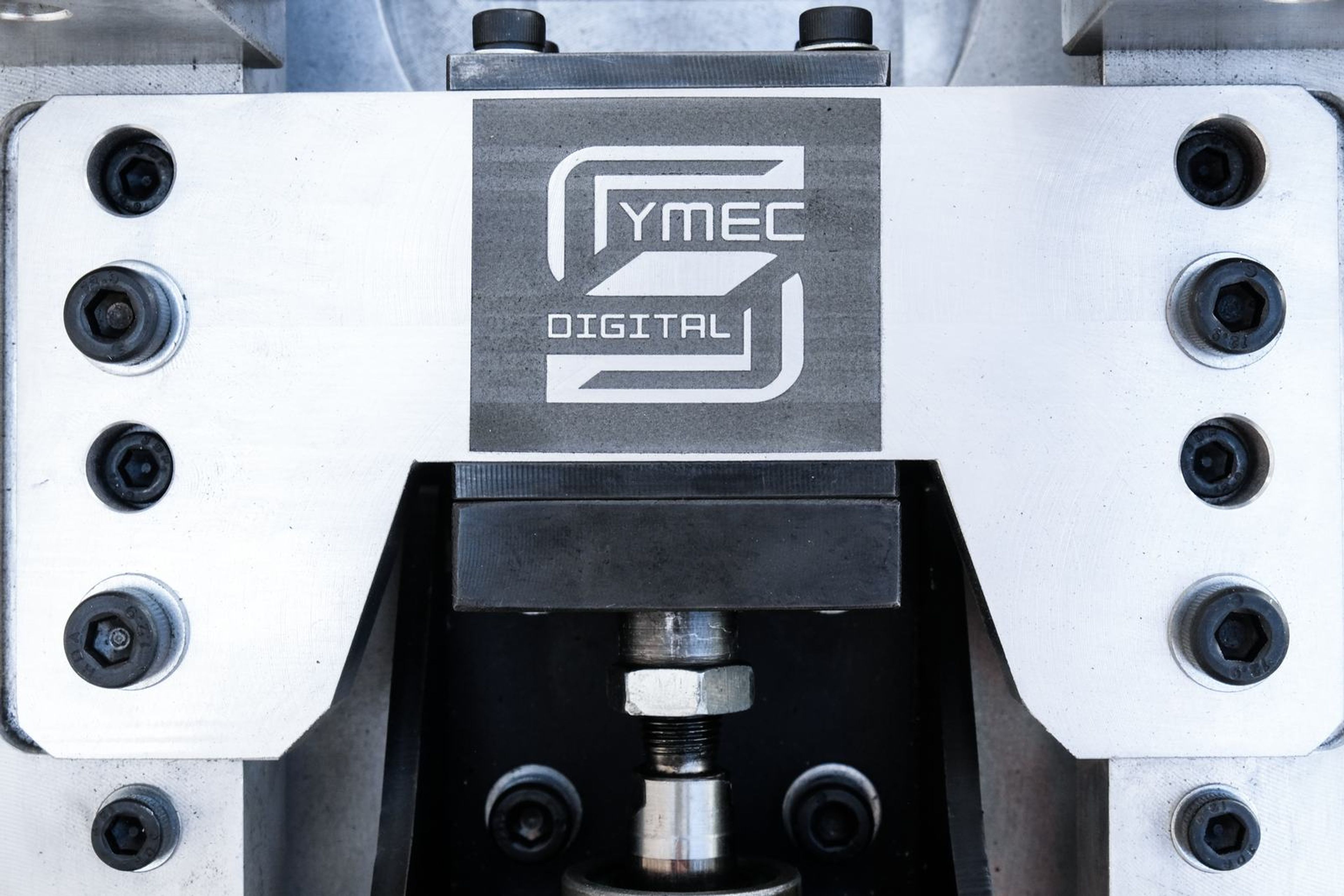 Retouched close view of the Symec logo plate and bolts