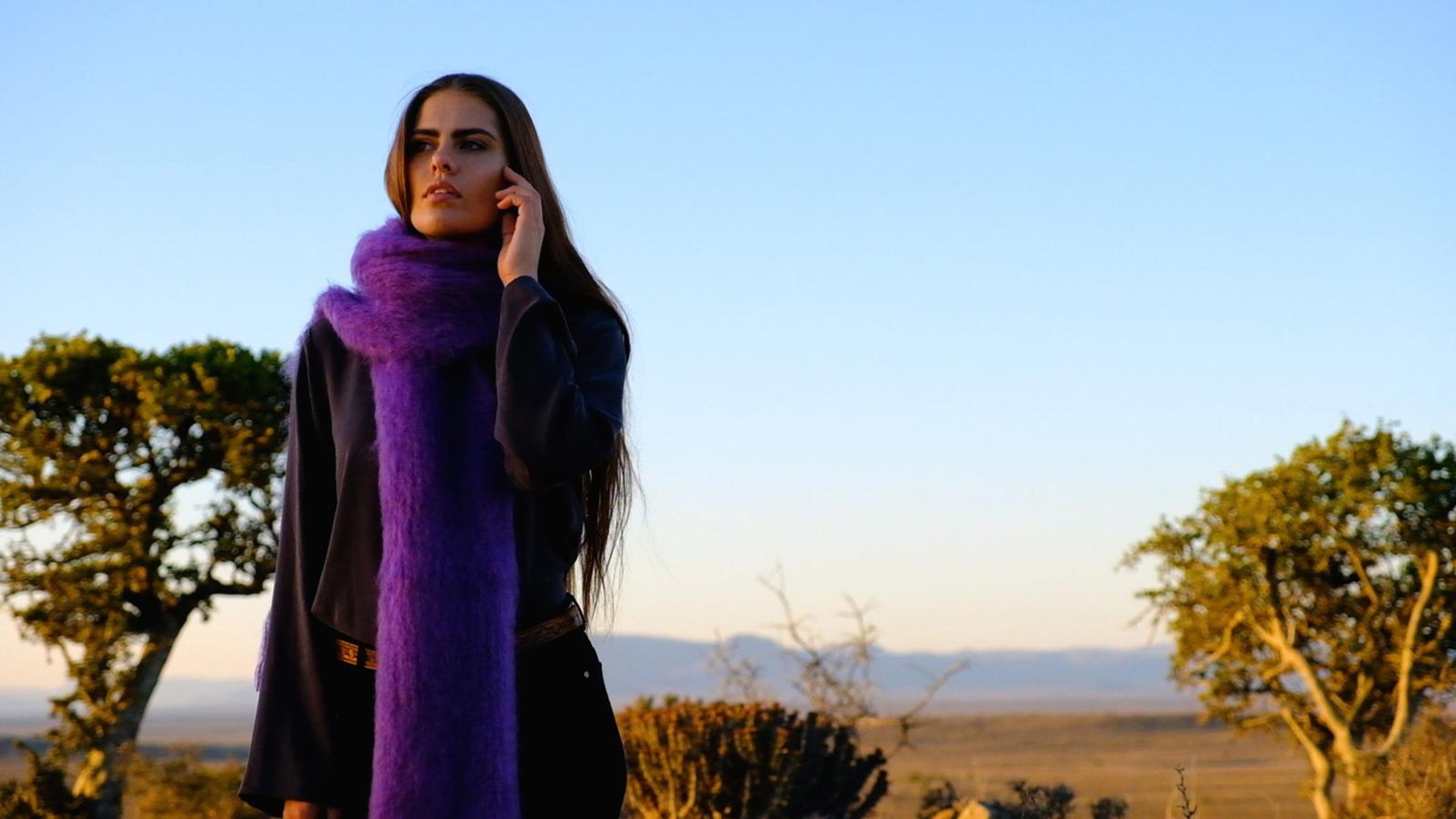 Model in a rich purple mohair scarf on the phone