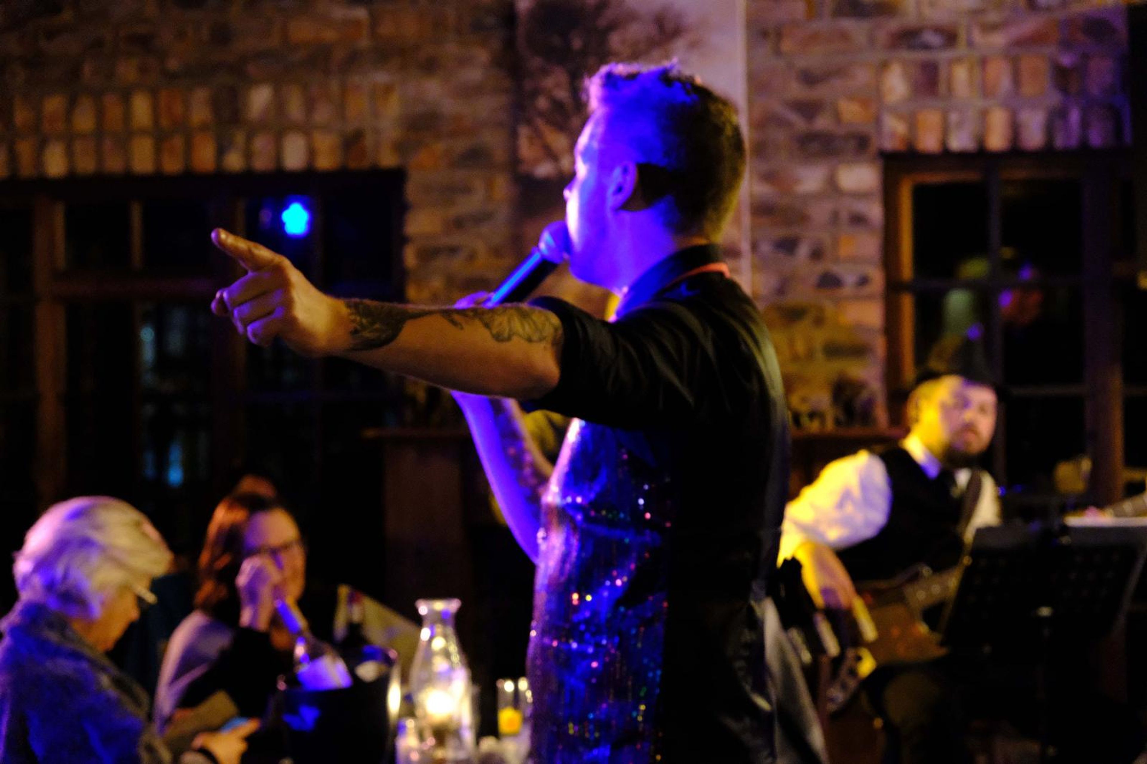 Lead singer pointing to the crowd while the bassist plays behind him