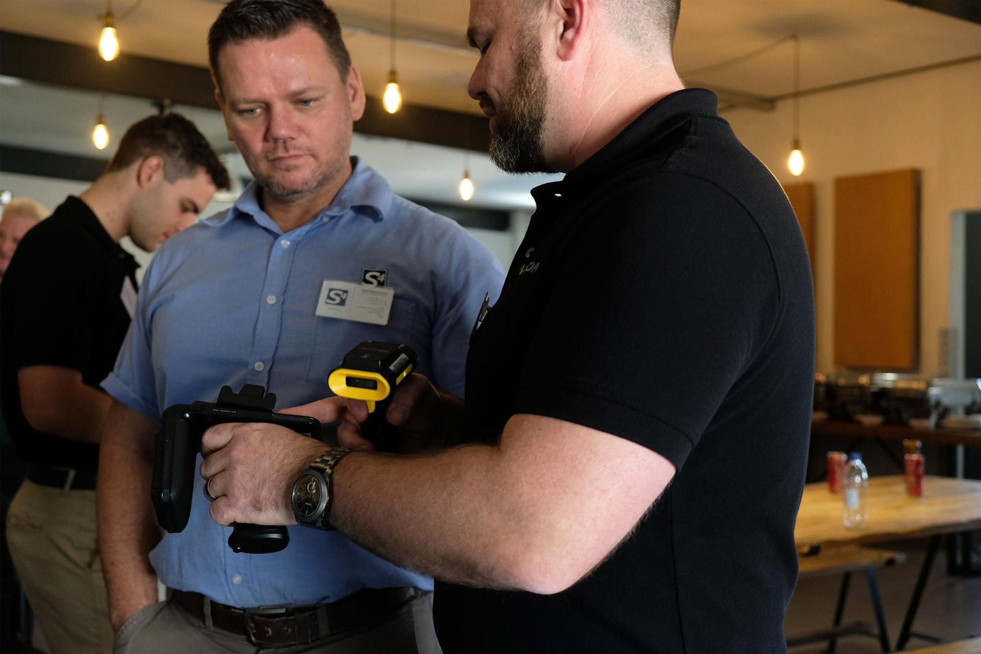 Servecom team member showing a handheld scanner to a visitor