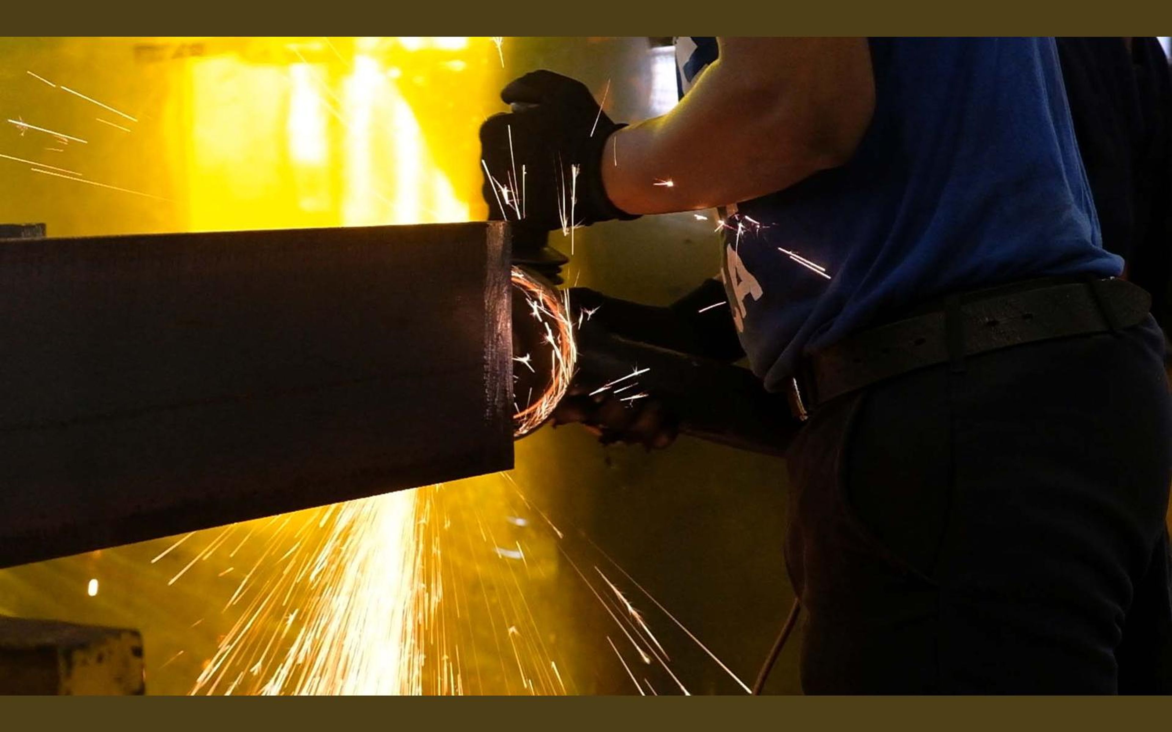 Worker with an angle grinder and a spray of sparks