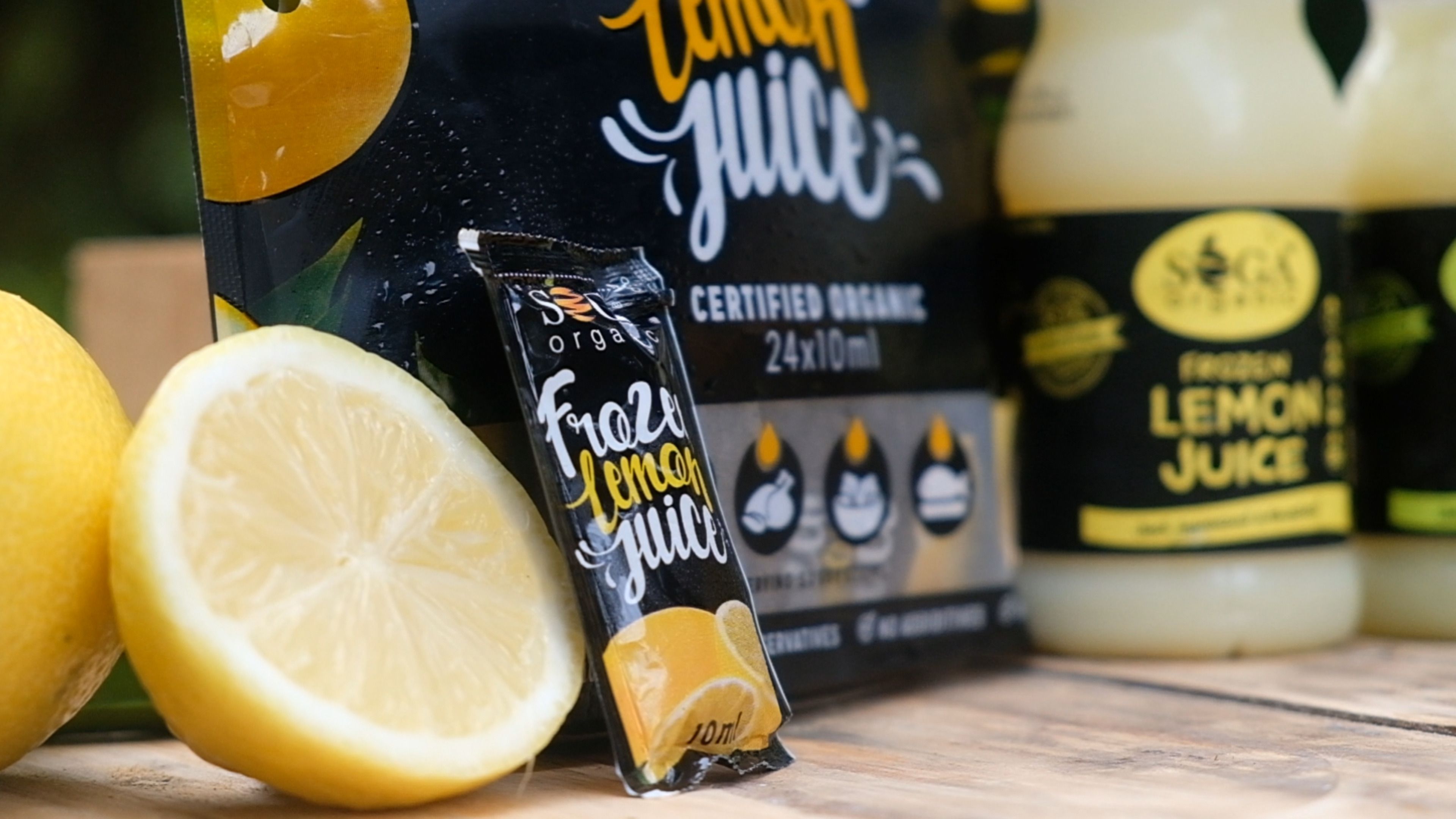 SOGA frozen lemon juice sachet standing beside a halved lemon and the sachet pack