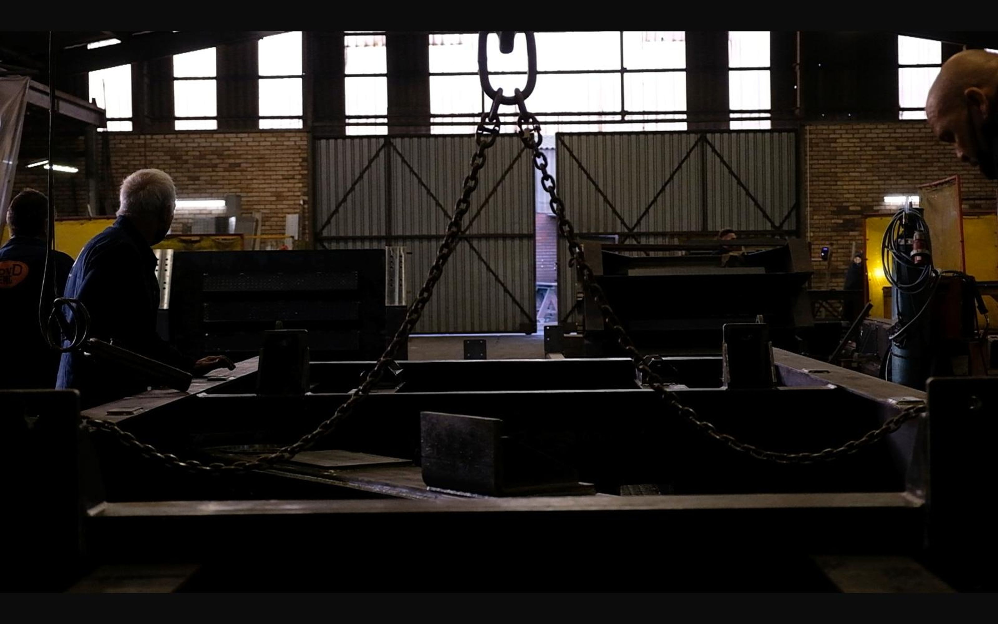 Workers gathered around a steel frame in the bay