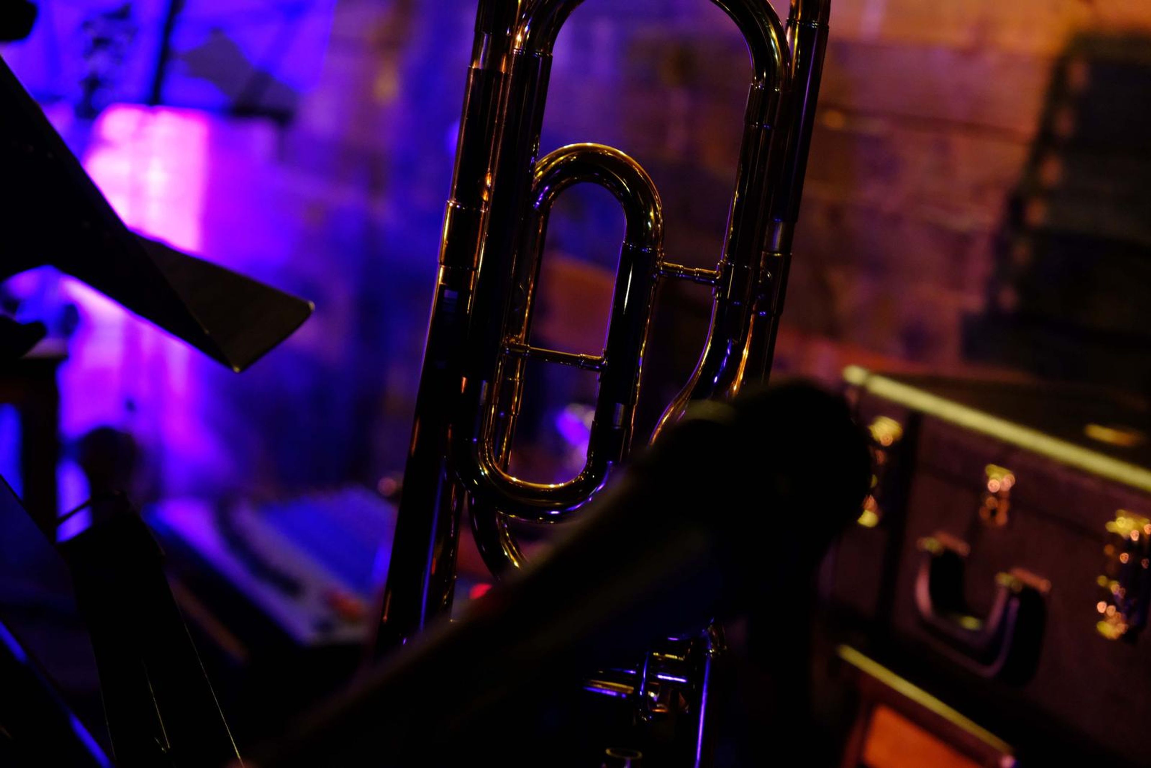 Close-up of a trombone bell in purple stage light
