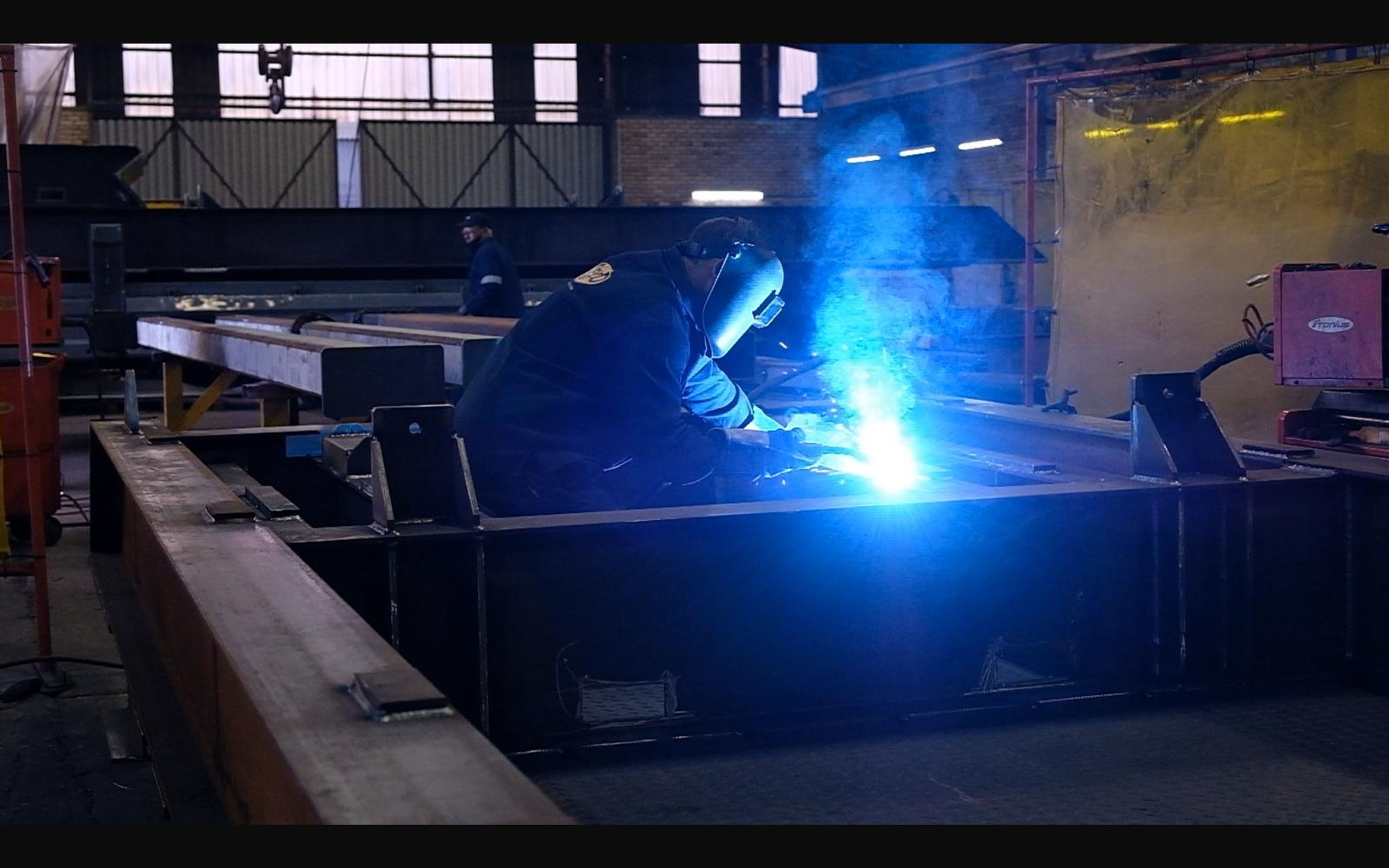 Welder joining a steel frame in the shop