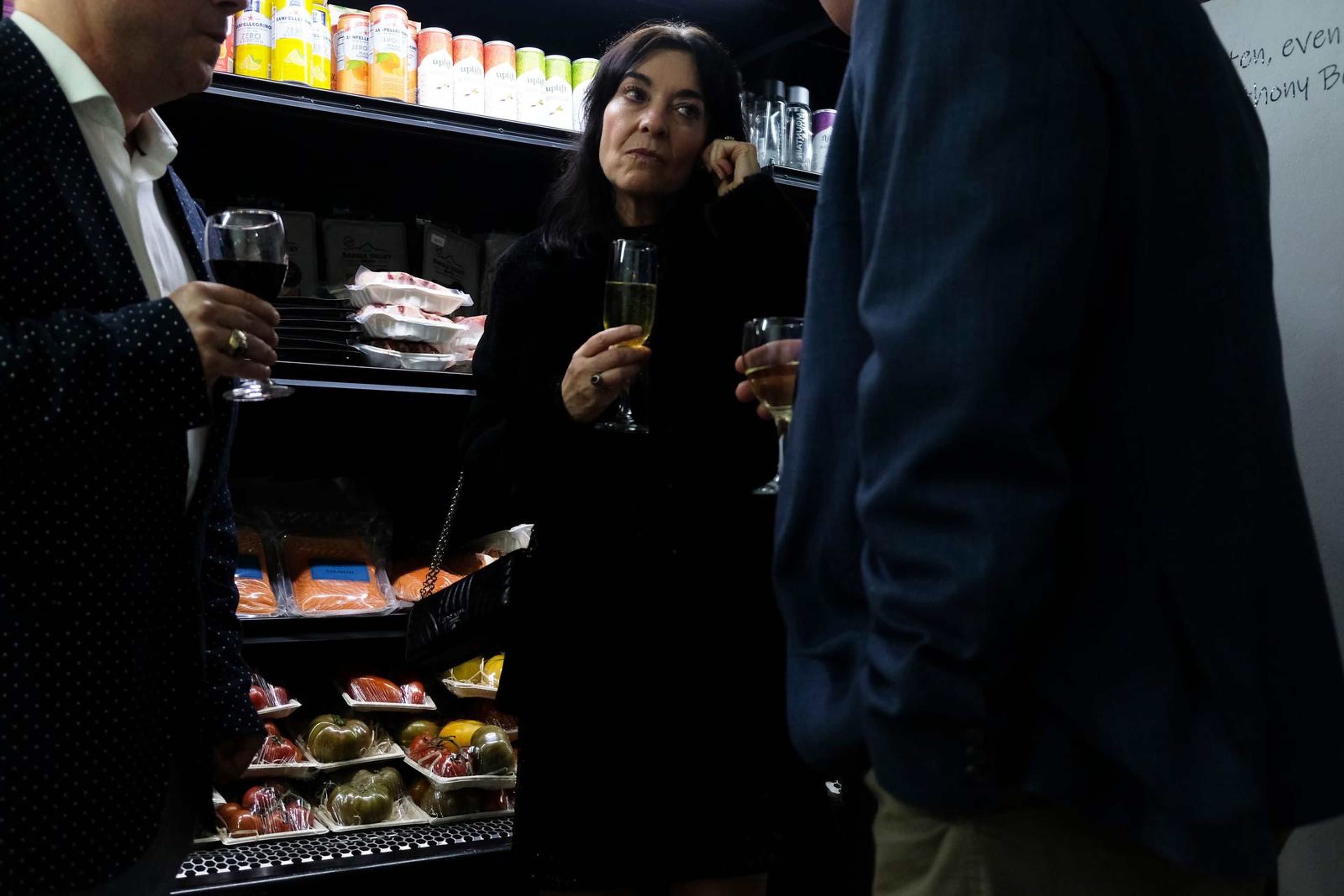 Guest in black holding a glass of champagne beside the chilled counter