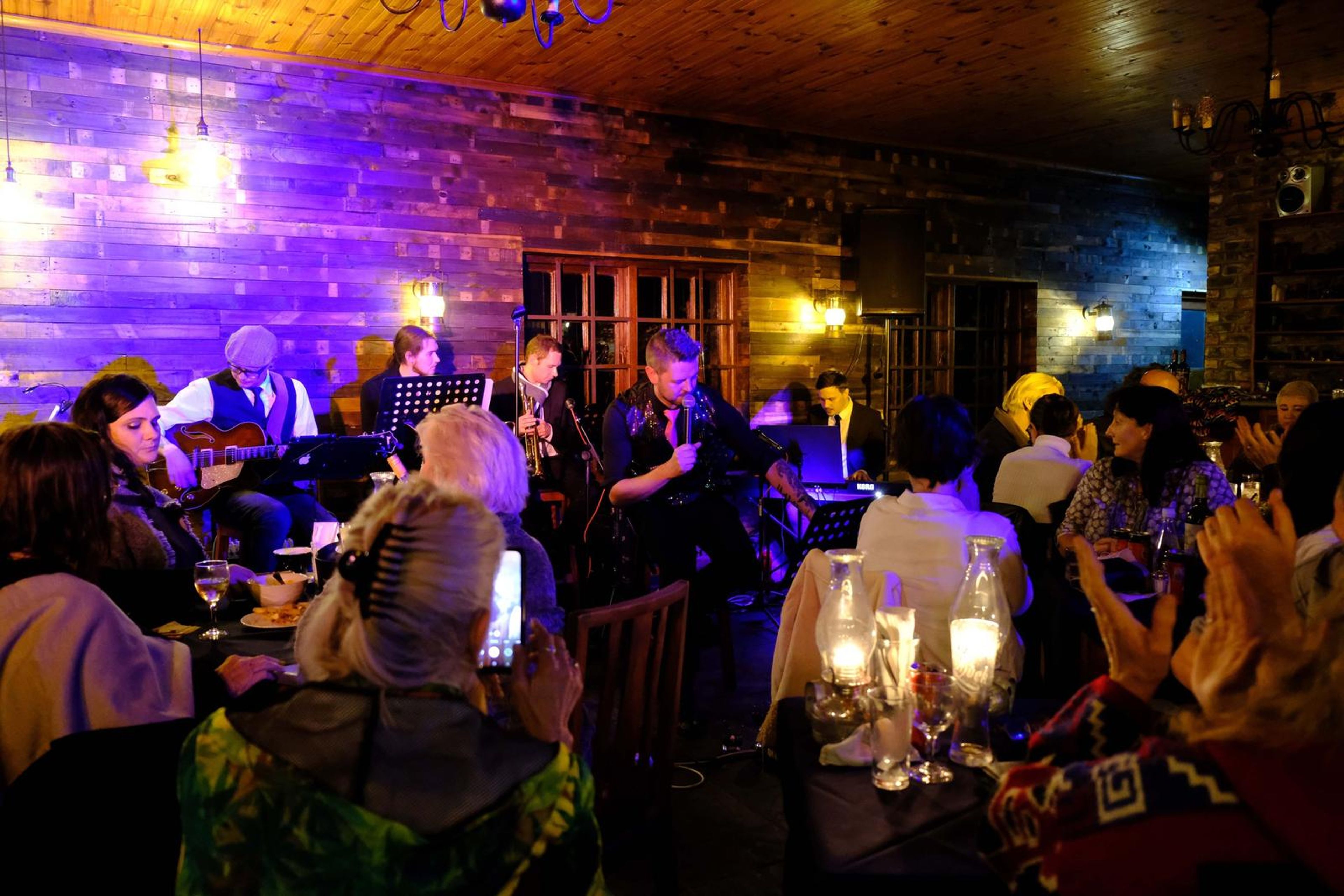 Wide view of the band on stage and the full room of diners
