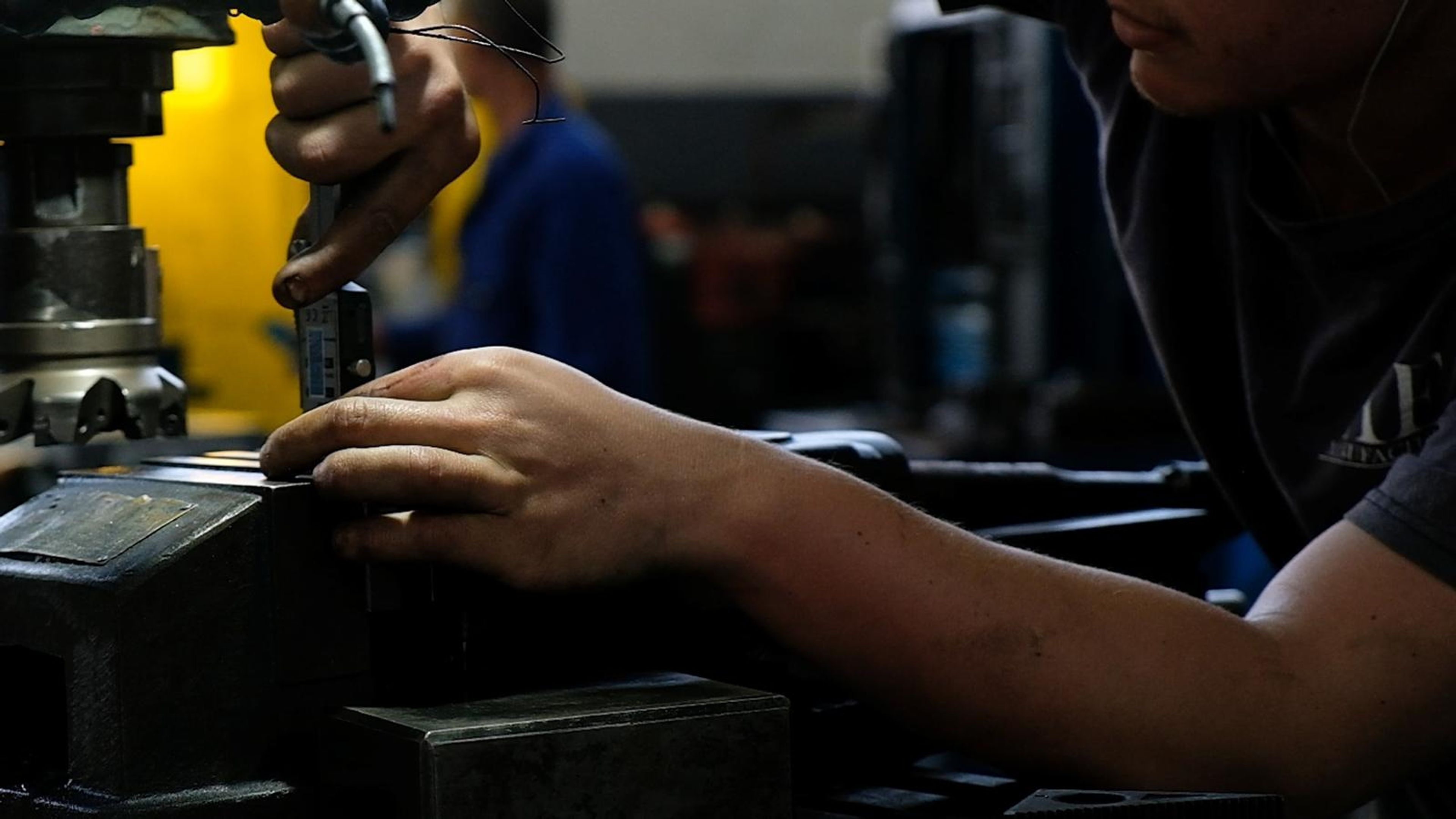 Hands checking a part in a machine vice
