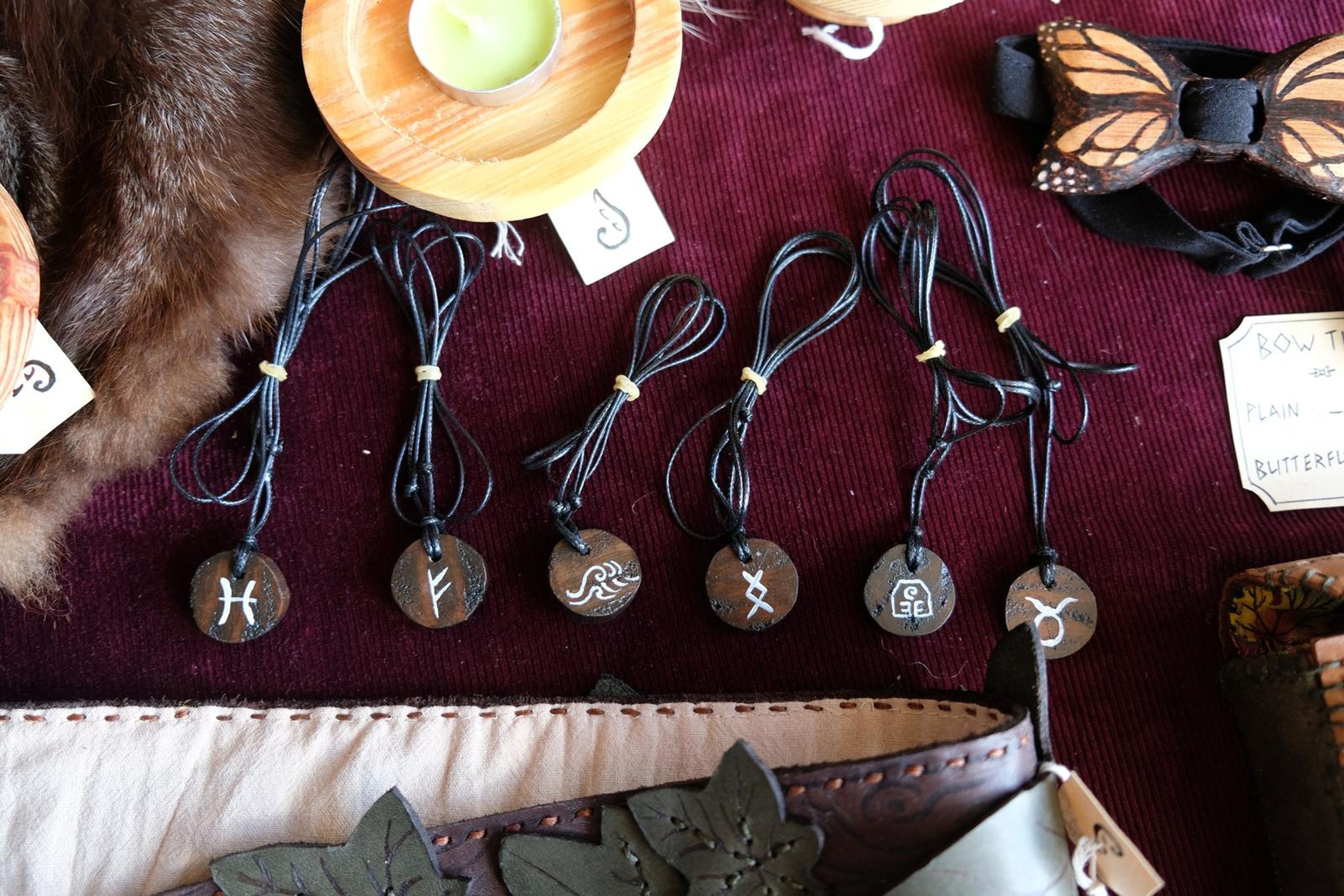 Row of wooden pendants on leather cords with engraved symbols