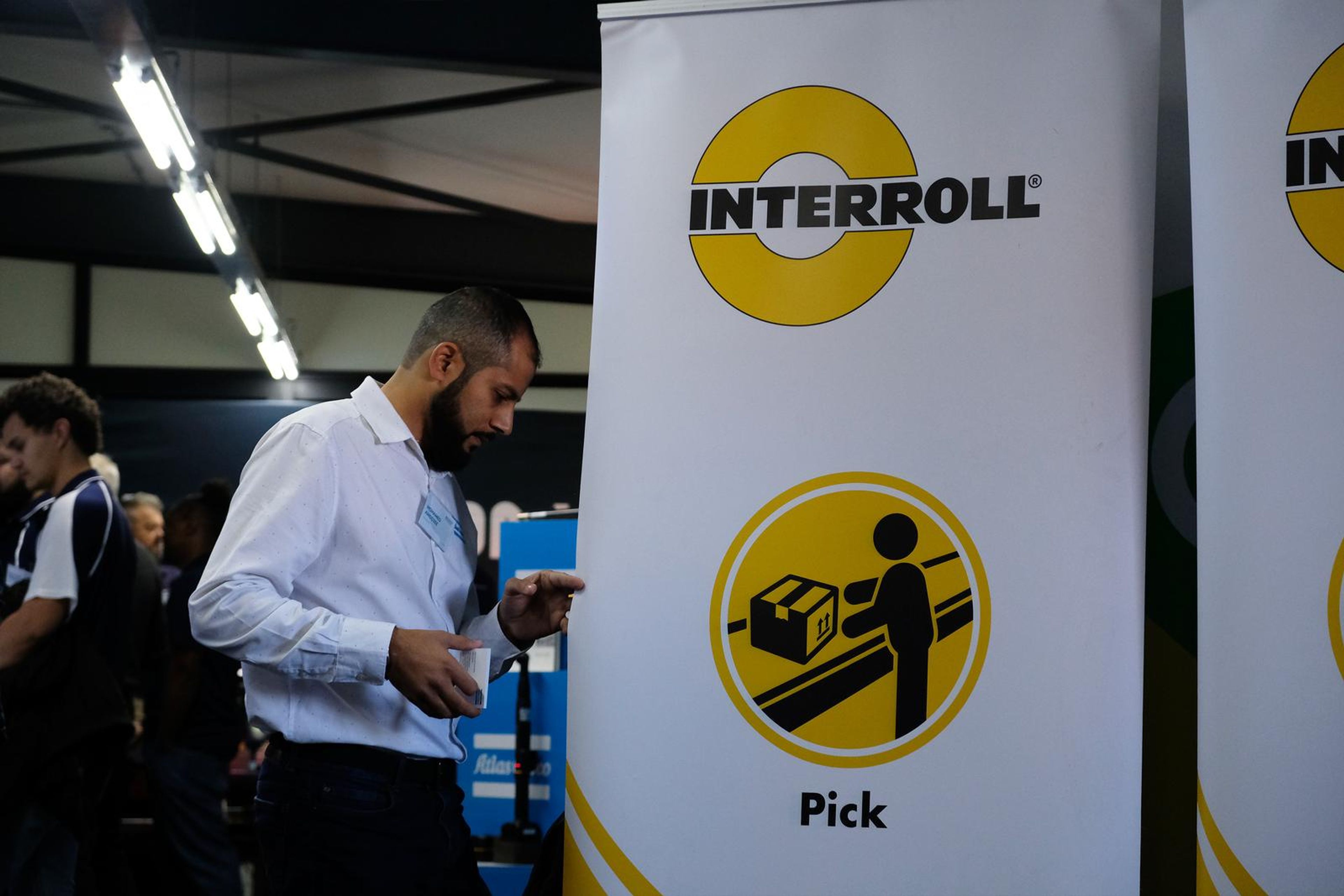Interroll Pick banner with a visitor at the stand