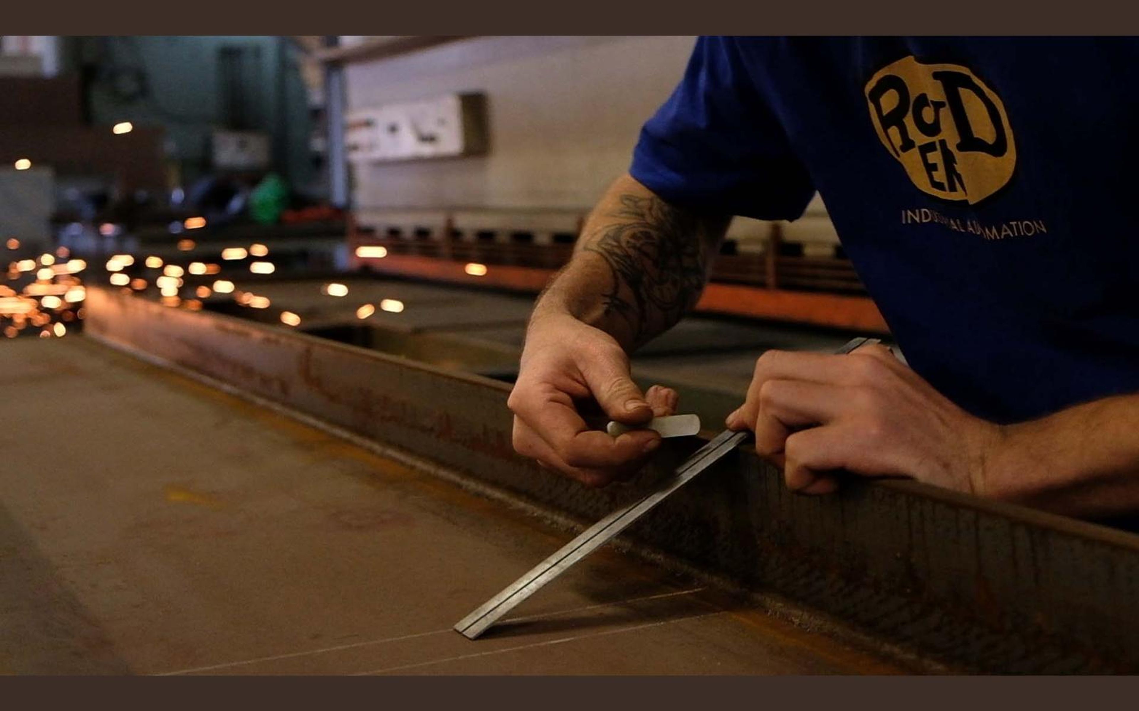 Fabricator in a ROVD shirt working at a steel bench