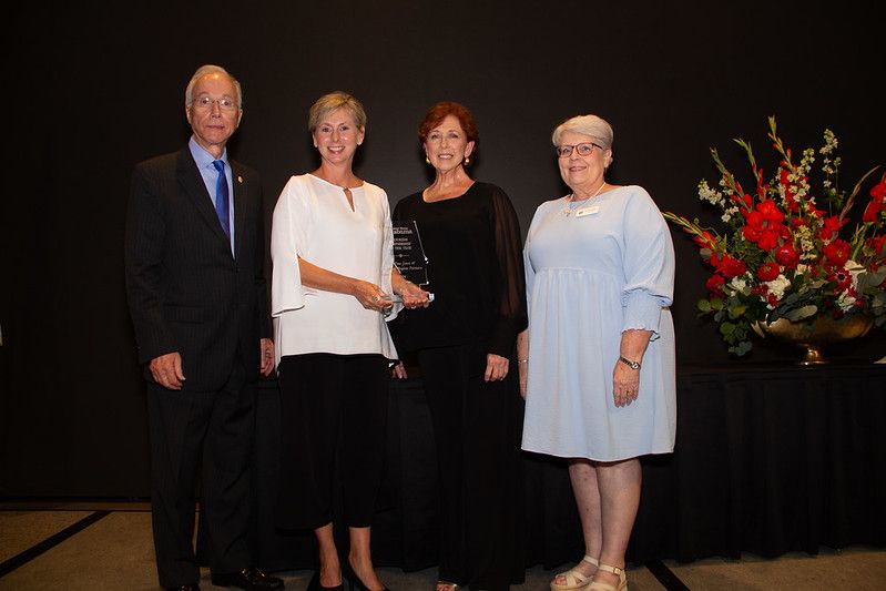 Four people are standing together in a formal setting. This is at the ATD Awards Banquet. Alabama Governor's Conference on Tourism 2024