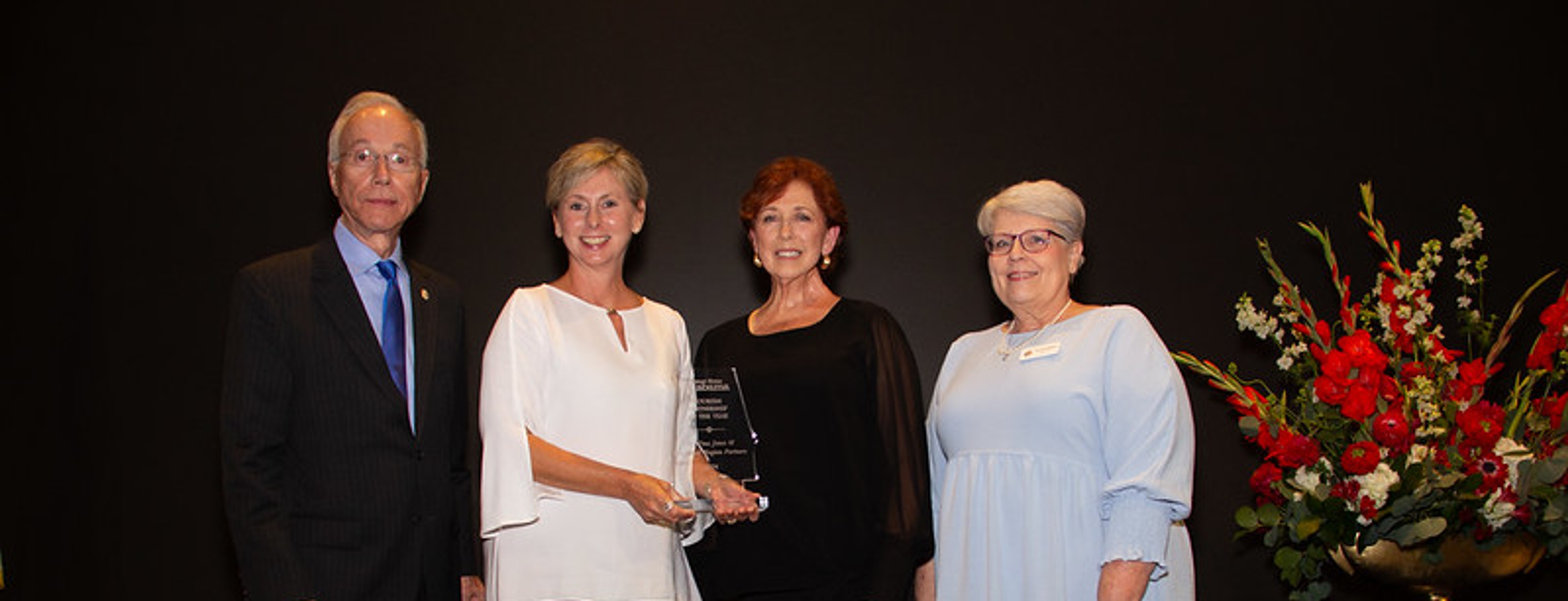 Four people are standing together in a formal setting. This is at the ATD Awards Banquet. Alabama Governor's Conference on Tourism 2024