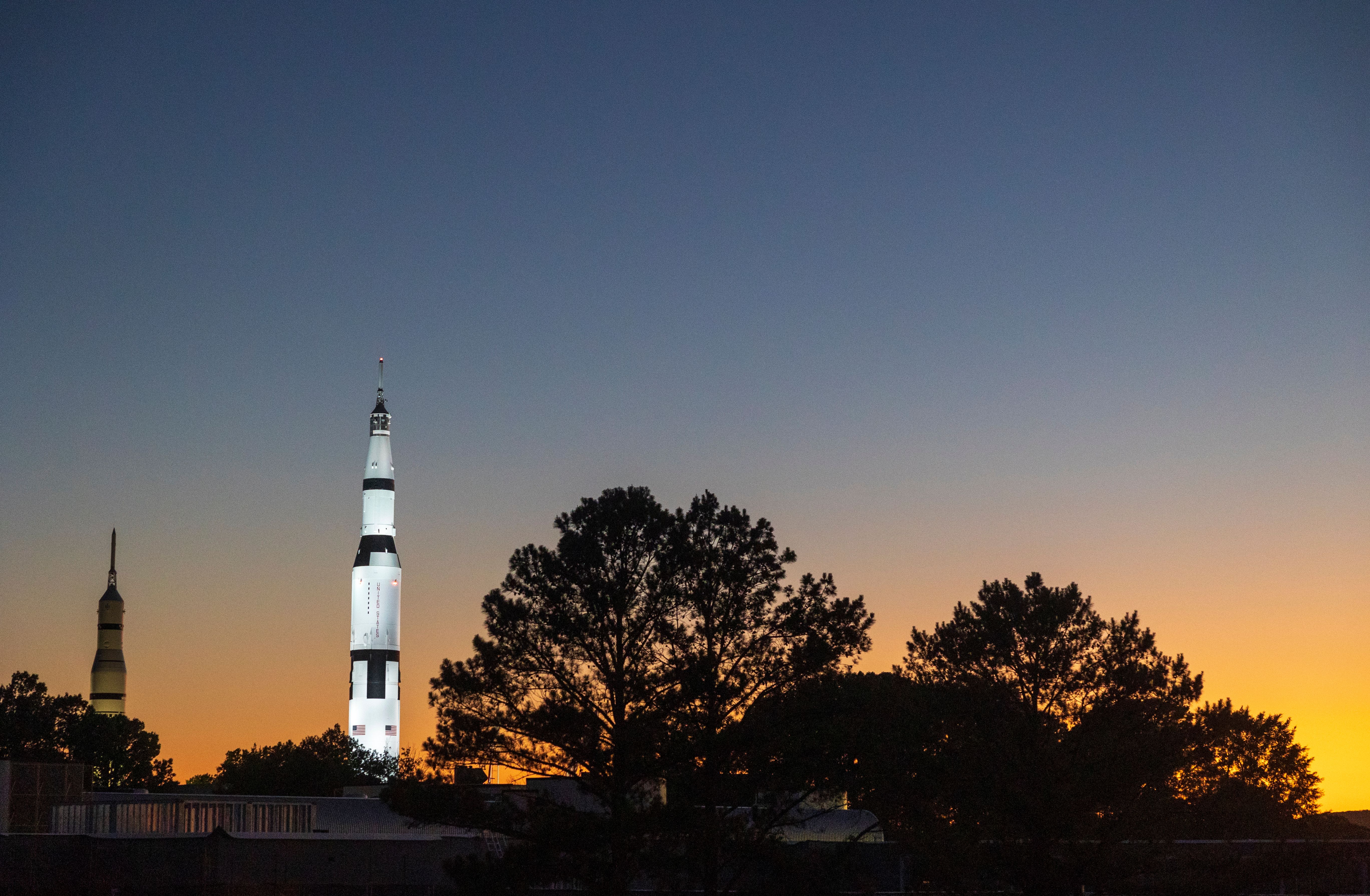 A photo of the U.S. Space & Rocket Center in Huntsville, AL. The sun is setting in the background.