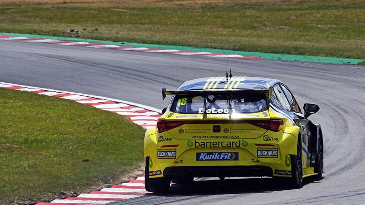 A yellow Duckhams-liveried touring car cornering on a circuit.