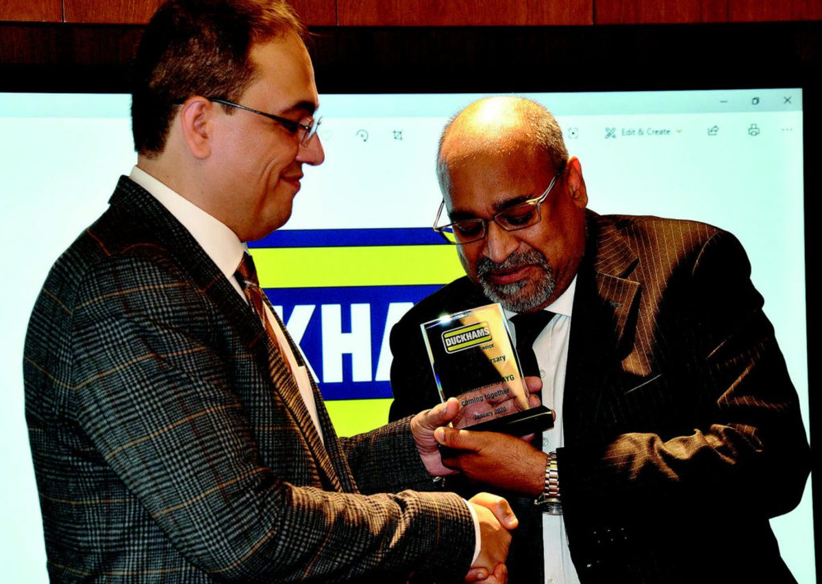 Two men examining an award together at a presentation.