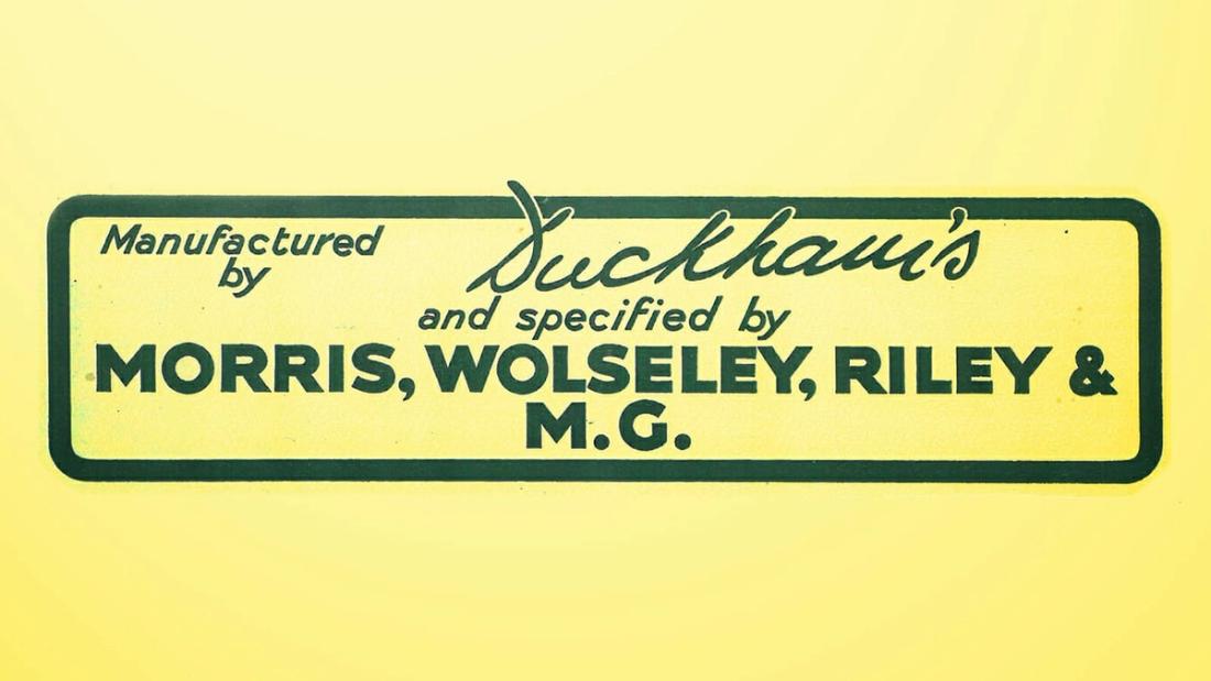 A yellow enamel sign reading "Manufactured by Duckham's and specified by Morris, Wolseley, Riley & M.G."