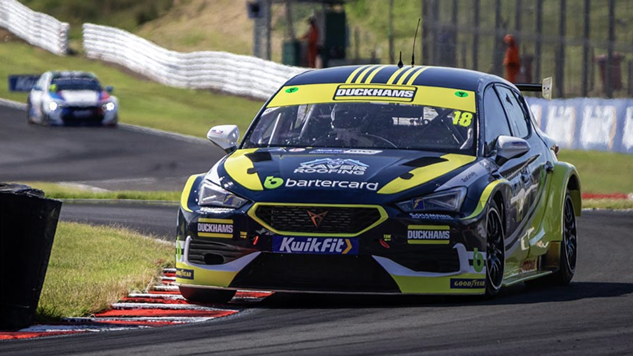 A yellow and blue Duckhams touring car at speed on a circuit.
