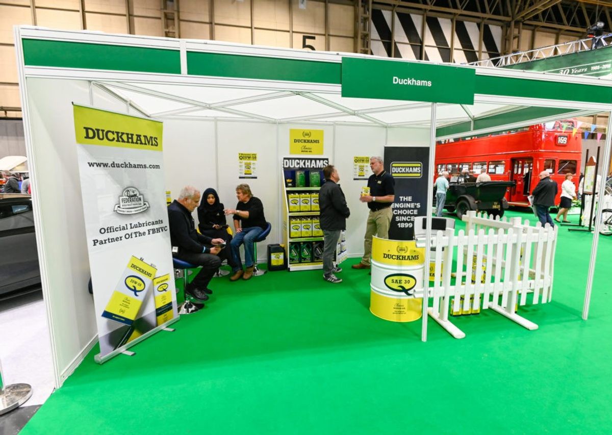 The Duckhams exhibition stand with green carpet, branded banners and seated visitors.