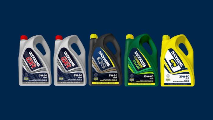Five Duckhams passenger car oil bottles in a row on a navy background.