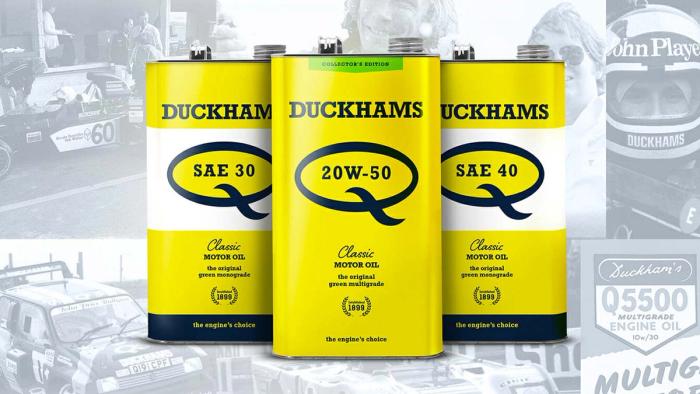 Three yellow Duckhams Classic Q cans in SAE 30, 20W-50 and SAE 40 over an archive racing image.