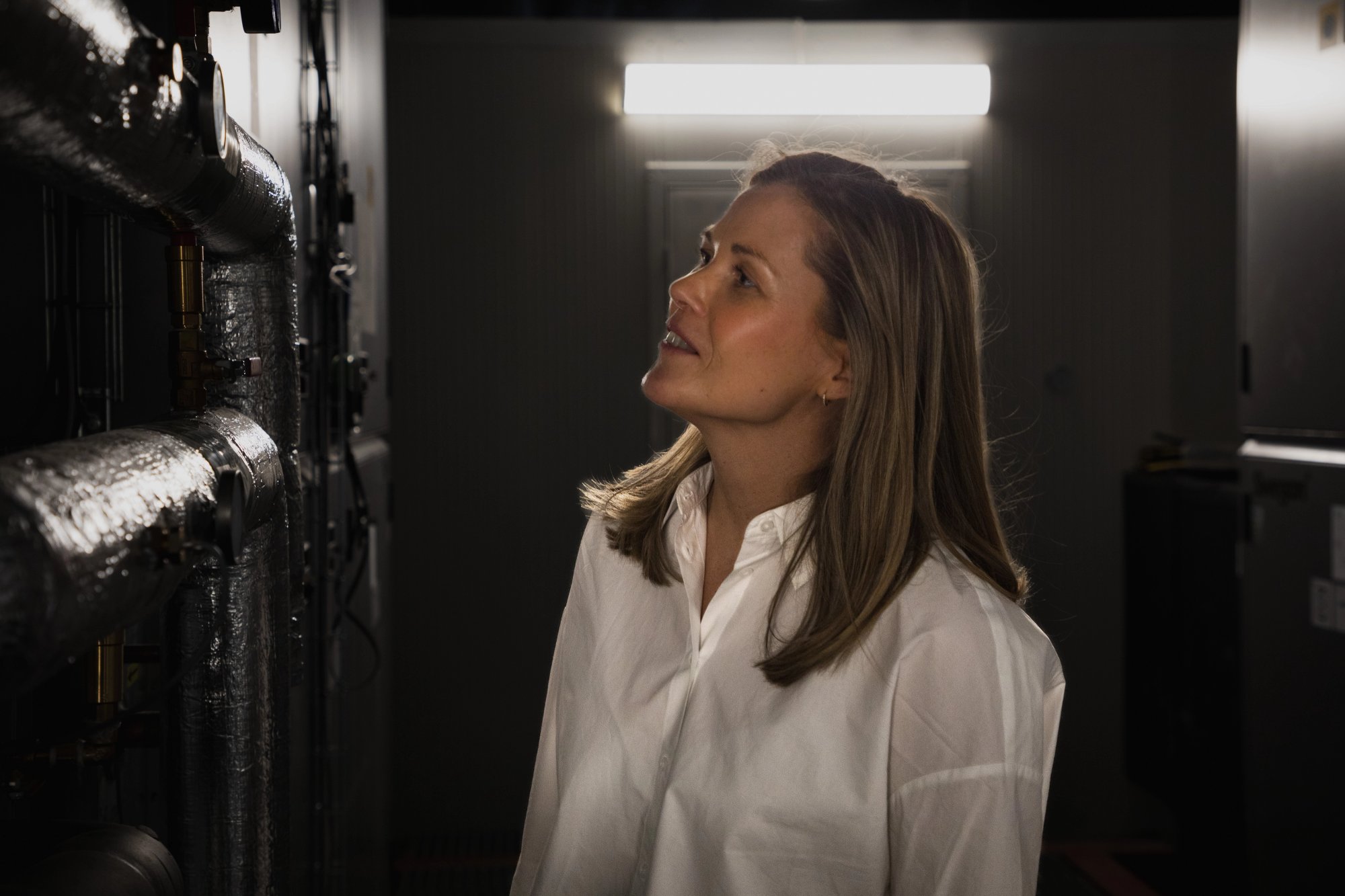 Julie Osland, project manager in adaptic looking at measurement tools in the technical room at E C Dahls. 